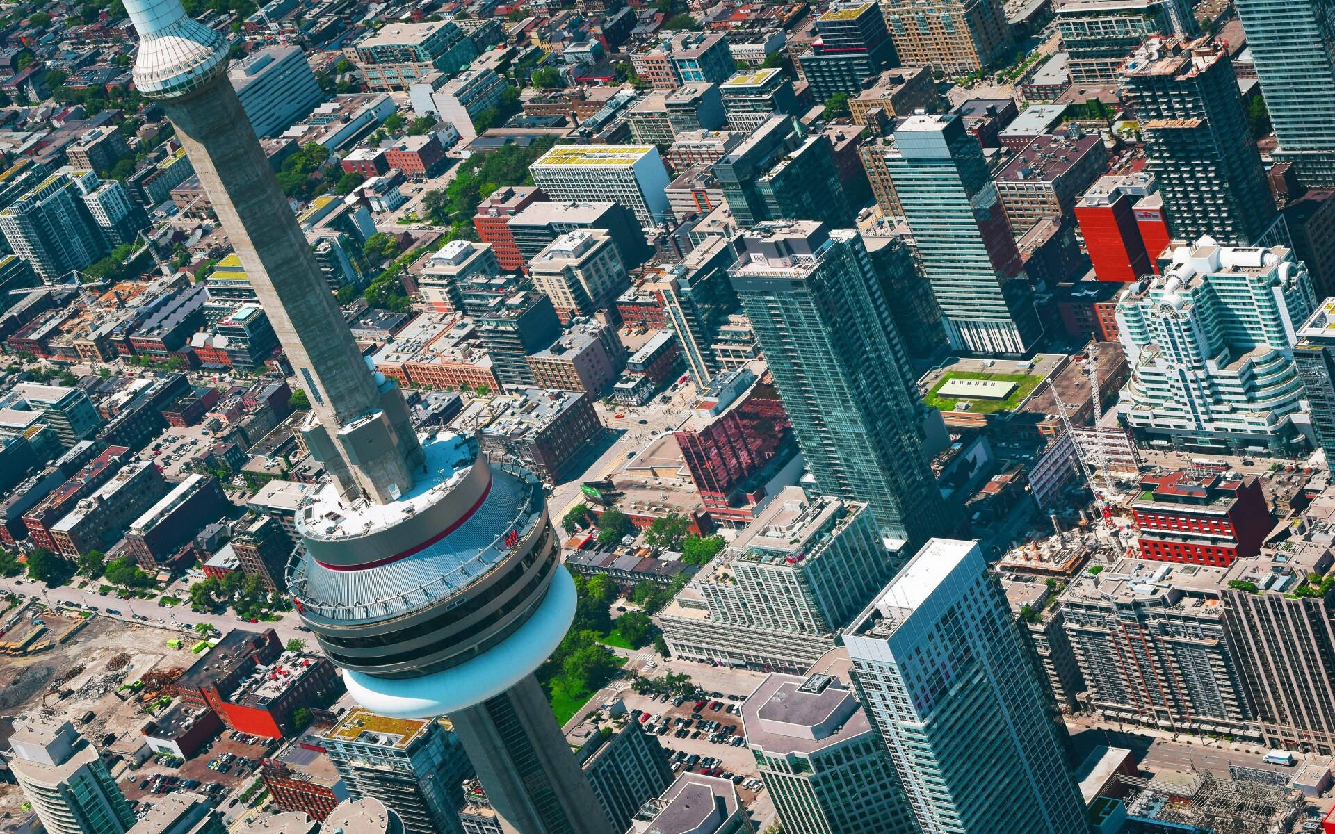 Toronto 桌布 壁紙 — 多倫多天際線的鳥瞰圖，以標誌性的CN塔為主導，周圍環繞著密集的現代摩天大樓和城市擴張。