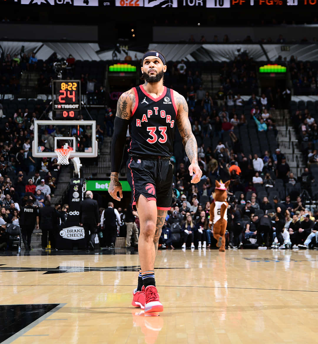 NBA 桌布 壁紙 — 多倫多暴龍隊籃球球員身穿33號球衣，在比賽期間自信地走在拋光球場上，背景有觀眾和吉祥物。