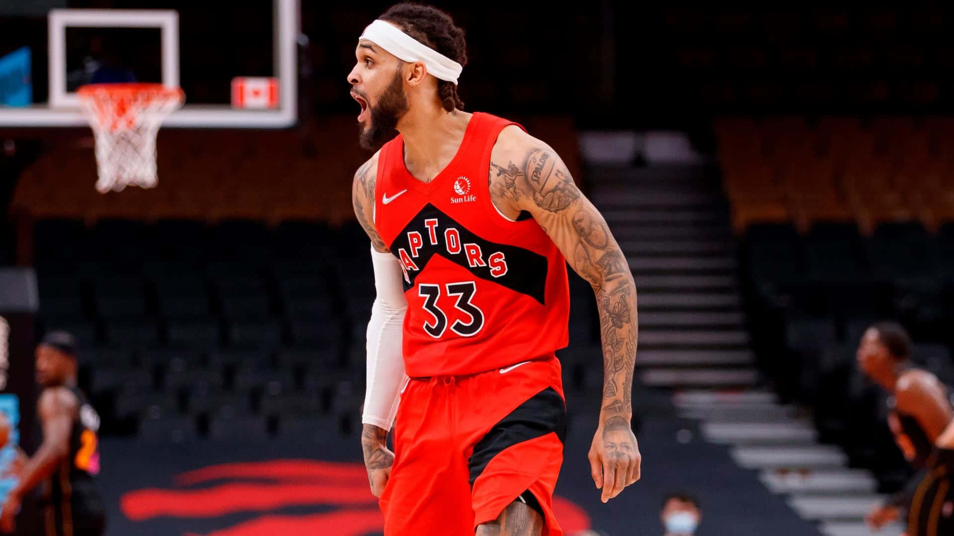 NBA 桌布 壁紙 — 多倫多暴龍隊籃球運動員身穿紅色33號球衣，在場館燈光下比賽時發出強烈的怒吼。