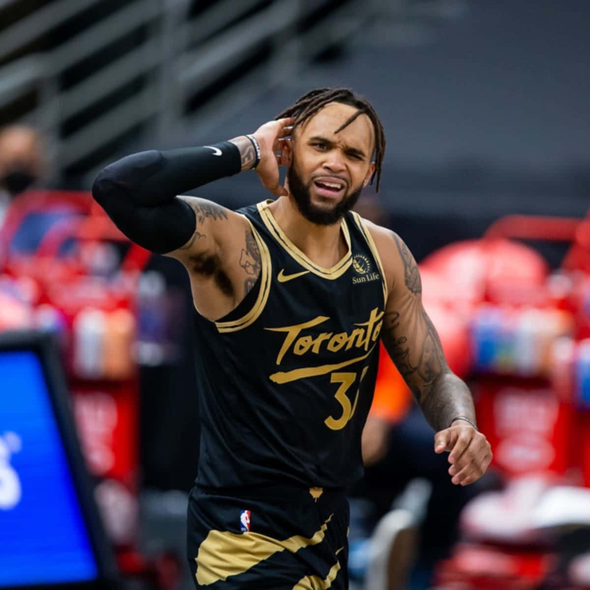 NBA 桌布 壁紙 — 多倫多暴龍隊籃球運動員身穿黑金色球衣，在比賽中將手放在頭上，表現出強烈反應。