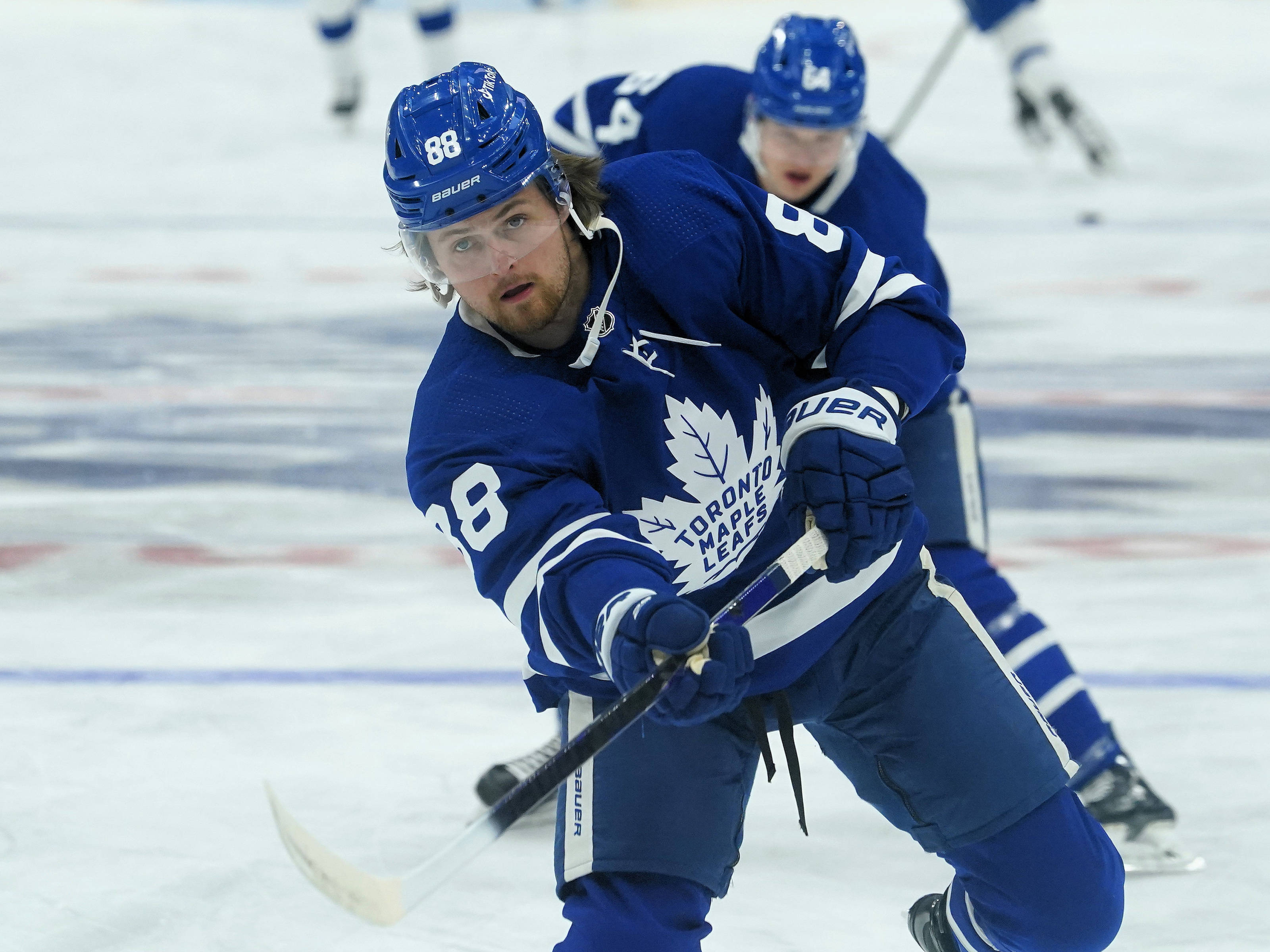 hockey 桌布 壁紙 — 多倫多楓葉隊冰球運動員身穿藍色88號球衣，在比賽中手持球桿在冰上激烈滑行。