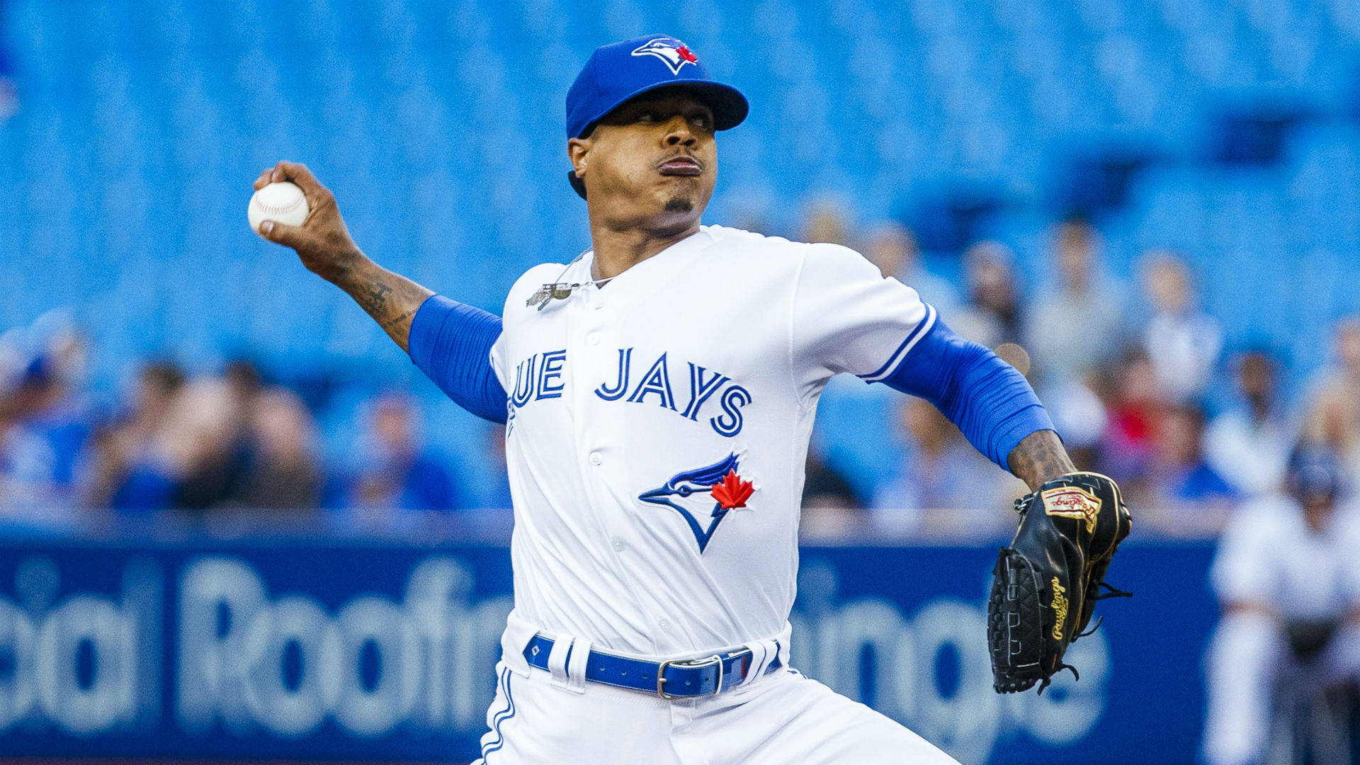 Marcus Stroman 桌布 壁紙 — 多倫多藍鳥隊投手在日間棒球比賽中投球，背景是模糊的體育場人群。