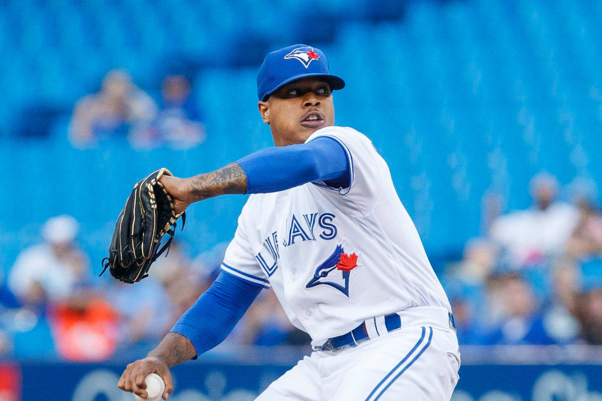 Marcus Stroman 桌布 壁紙 — 多倫多藍鳥隊棒球投手在模糊的球場背景下，專注地投球中。