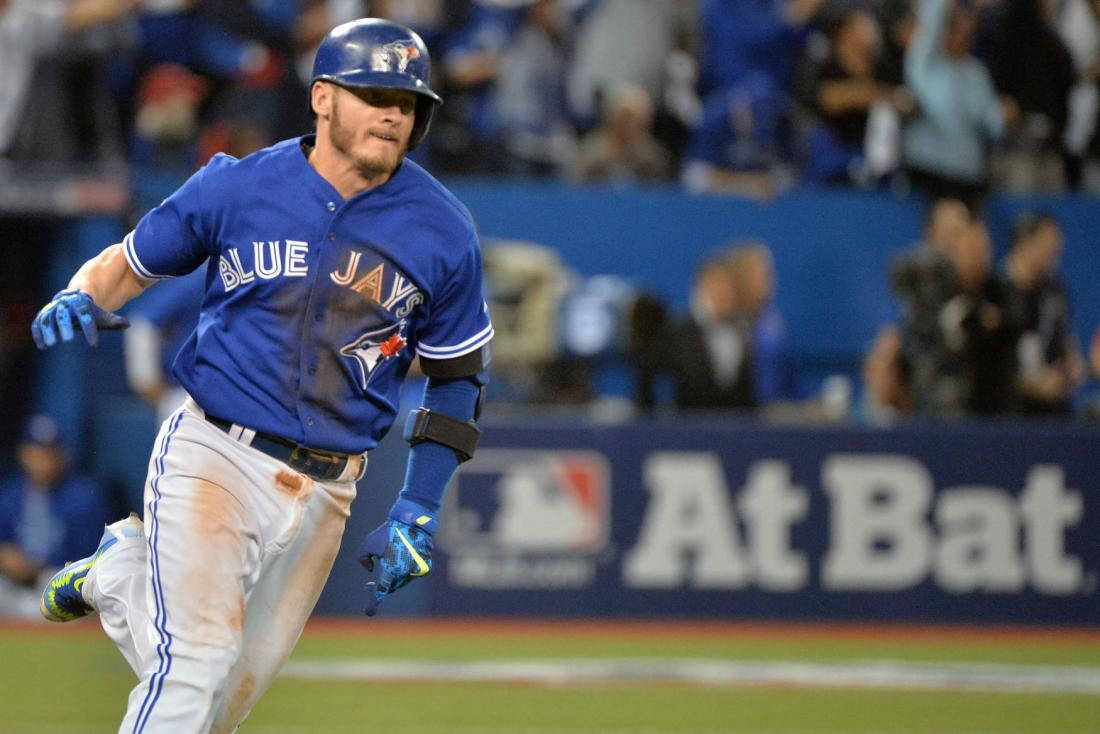 Toronto Blue Jays 桌布 壁紙 — 多倫多藍鳥隊棒球運動員在夜間比賽中衝過球場，體育場燈光照亮他的藍色球衣。