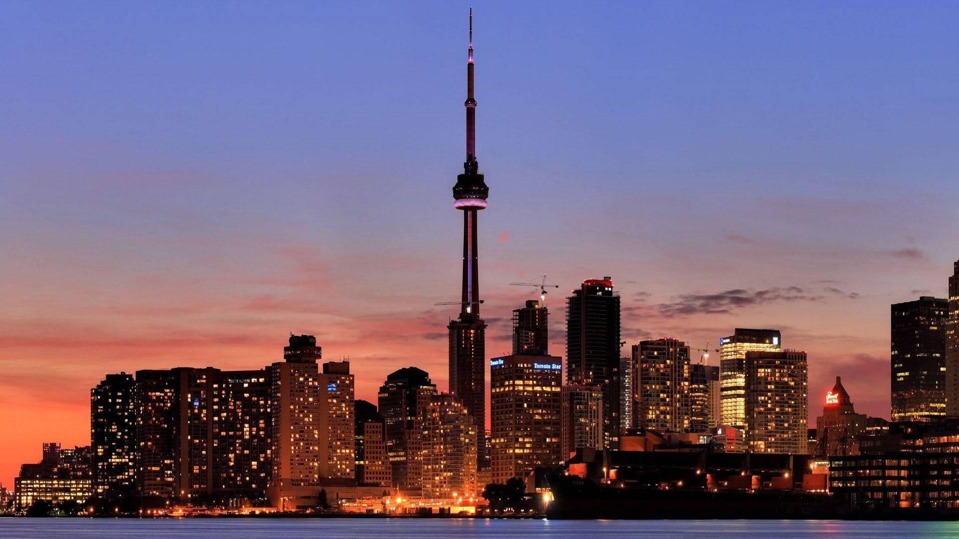 Ontario 桌布 壁紙 — 多倫多黃昏天際線，CN 塔在紫色、橙色和藍色的漸變天空下亮起。