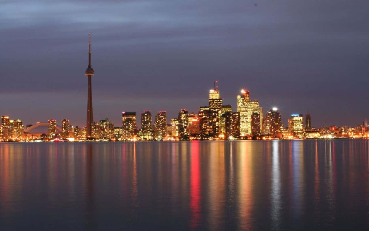 Toronto 桌布 壁紙 — 多倫多黃昏天際線，CN塔和摩天大樓在平靜的水面上閃耀倒影。