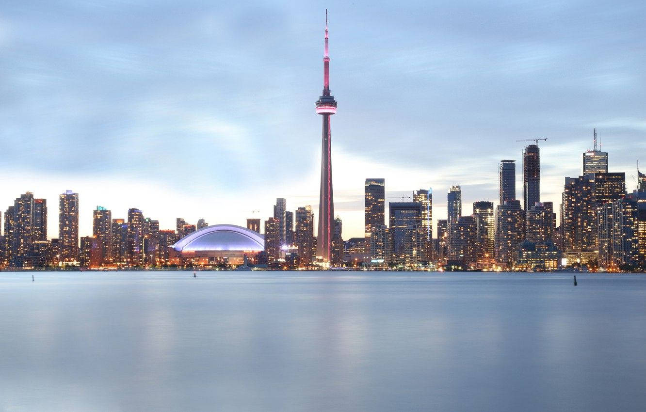 Ontario 桌布 壁紙 — 多倫多黃昏天際線，CN塔在平靜水面上方發出紅光，倒映城市燈光。
