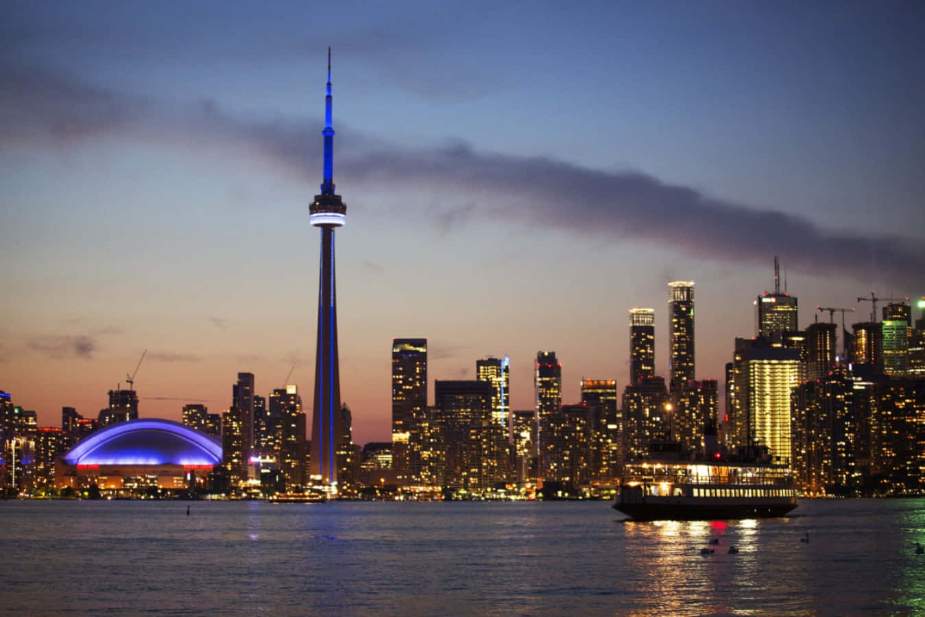 Toronto Skyline 桌布 壁紙 — 多倫多黃昏天際線，CN塔發出藍光，城市燈光倒映在水面上。