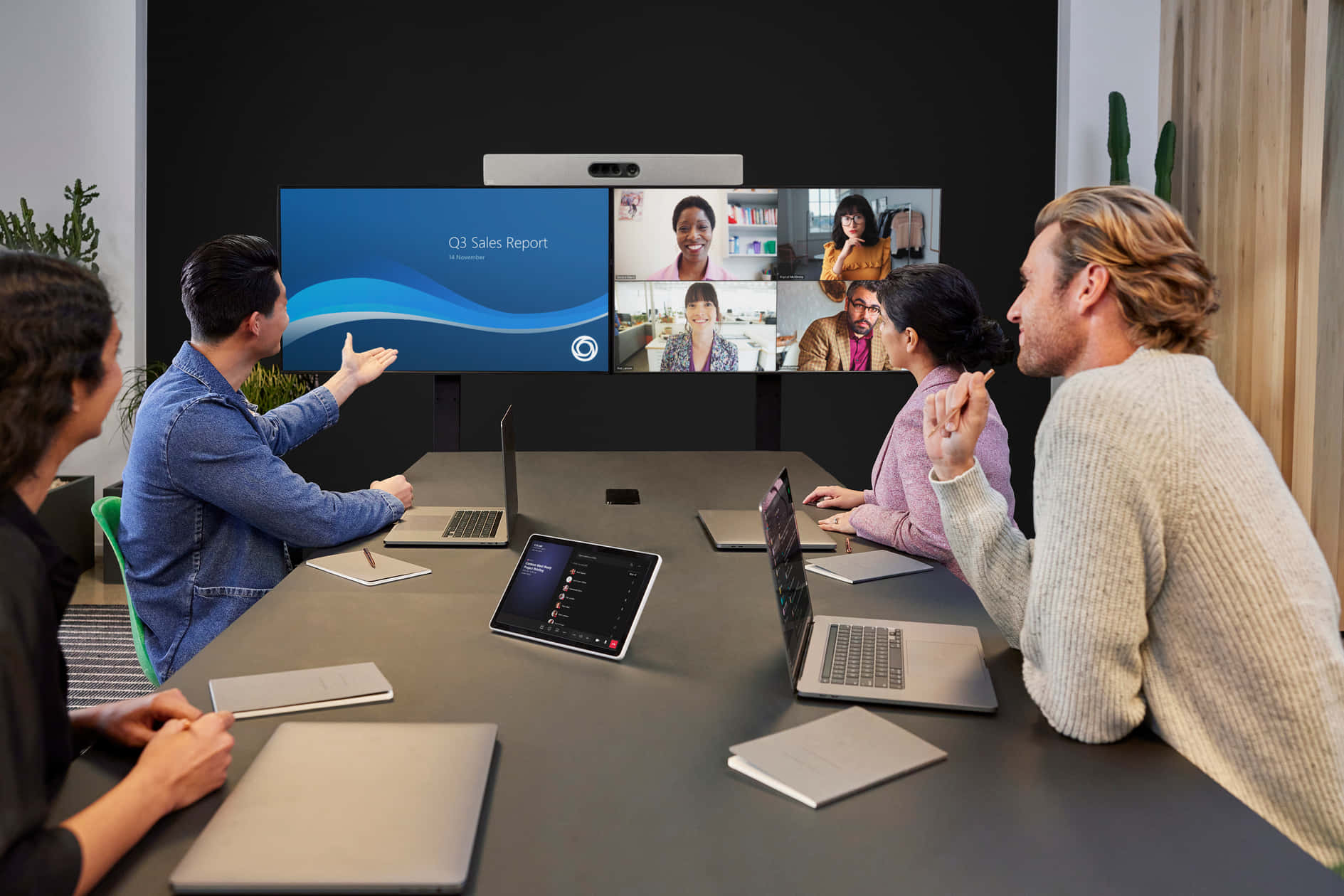 Microsoft Teams 桌布 壁紙 — 多元團隊在現代會議室透過視訊通話協作，大螢幕顯示第三季度銷售報告。