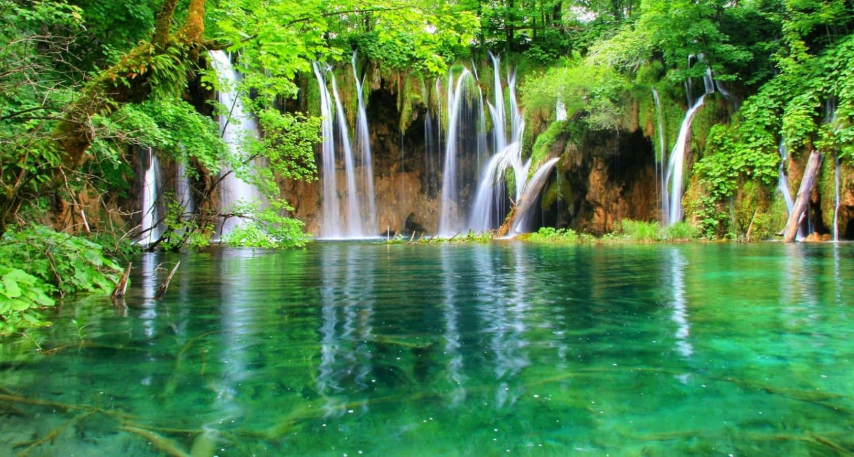 Croatia 桌布 壁紙 — 多層瀑布傾瀉而下，落入一個被茂密綠色森林環繞的清澈碧綠水池中。