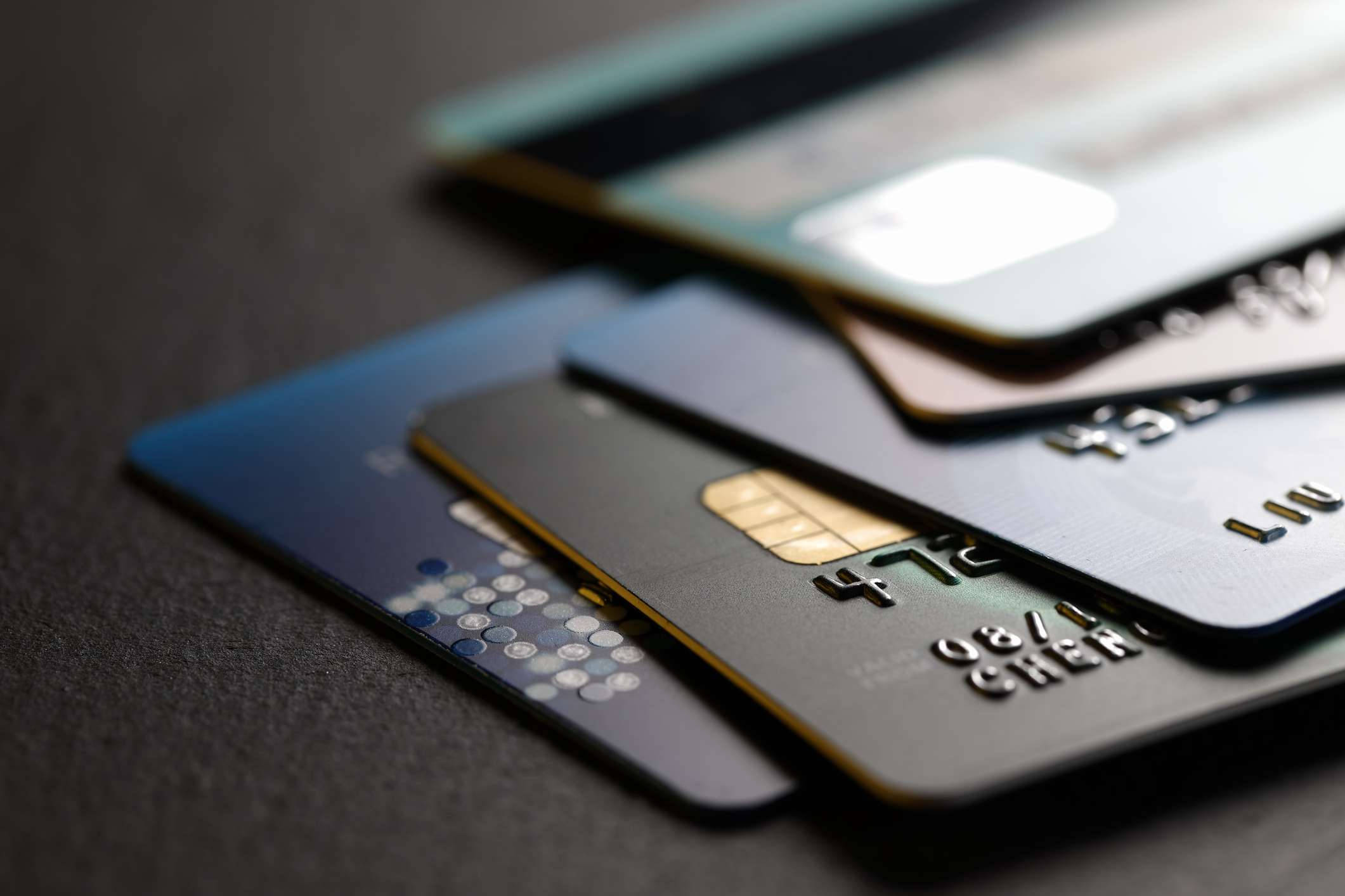 Credit Card 桌布 壁紙 — 多張信用卡在深色紋理表面上展開的特寫，景深較淺。