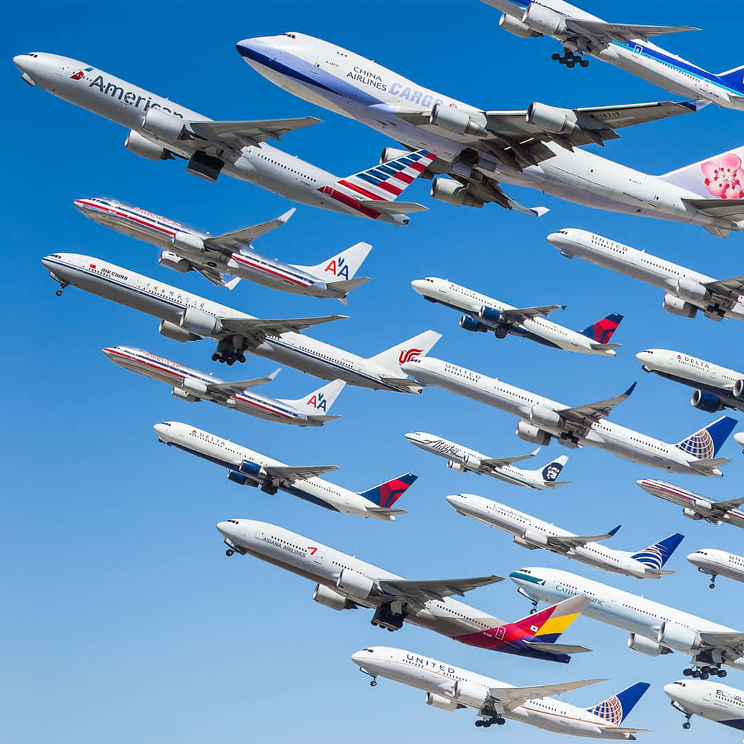 飛機 桌布 壁紙 — 多架來自不同航空公司的商用飛機以動態空中編隊形式對角線飛過清澈的藍天。