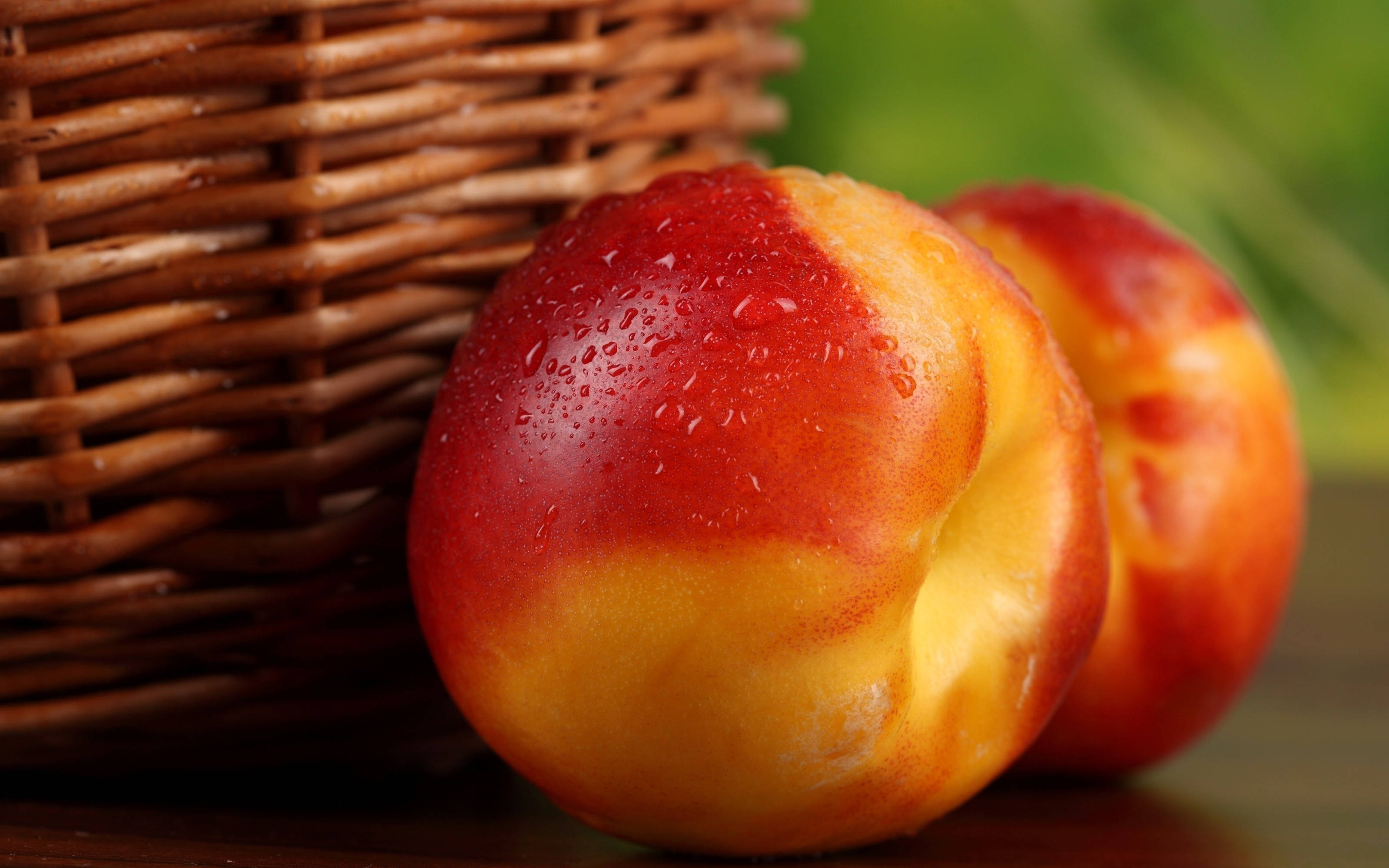 Fruits 桌布 壁紙 — 多汁成熟的桃子在木質表面上的編織籃旁閃爍著露珠。