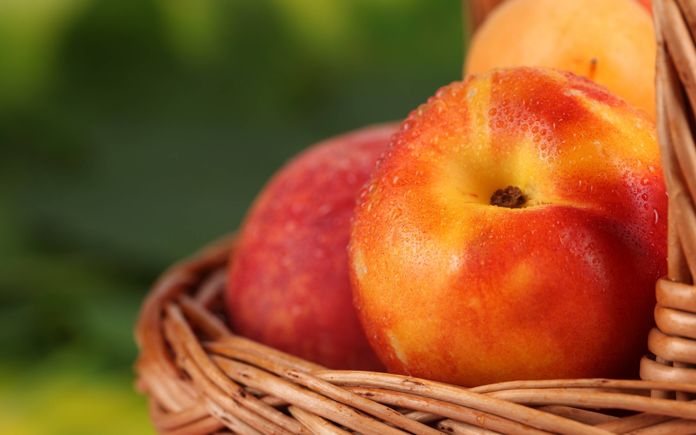 Fruit 桌布 壁紙 — 多汁成熟的桃子在編織柳條籃中閃爍著露珠，背景是柔和的綠色。