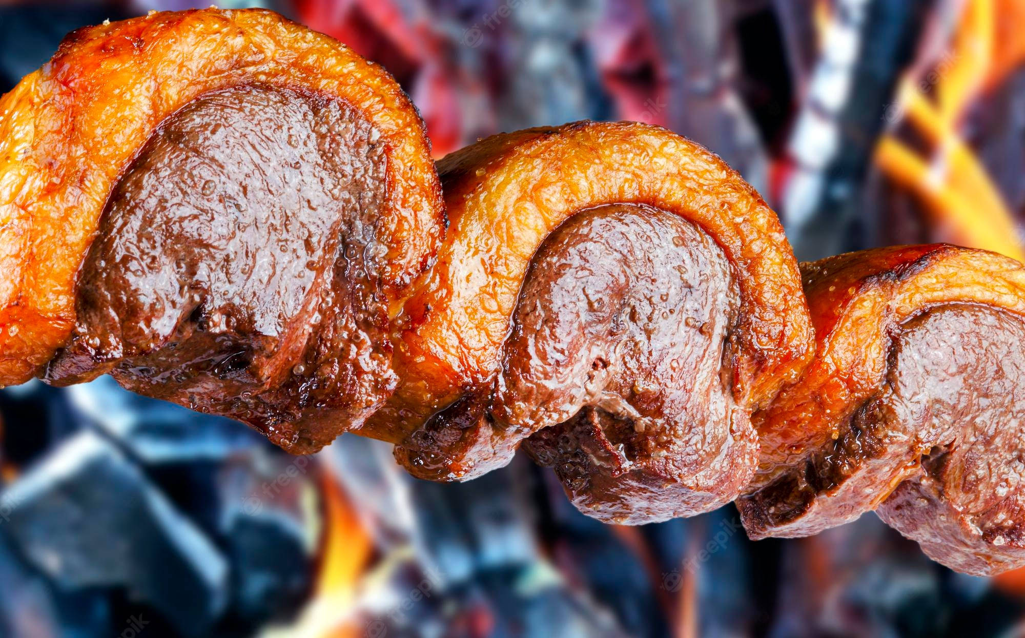 meat 桌布 壁紙 — 多汁燒烤肉塊在熾熱餘燼和火焰上的串燒特寫。