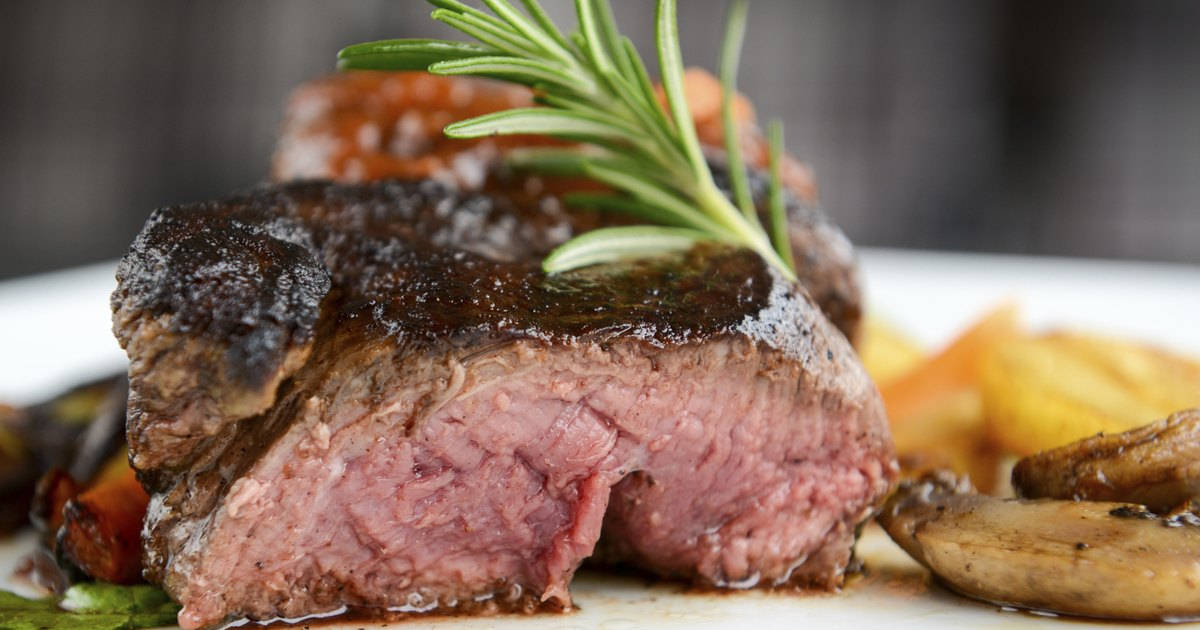 Liver 桌布 壁紙 — 多汁的 medium-rare 牛排，表面煎出焦脆外皮，搭配新鮮迷迭香，與烤蔬菜一起盛盤。
