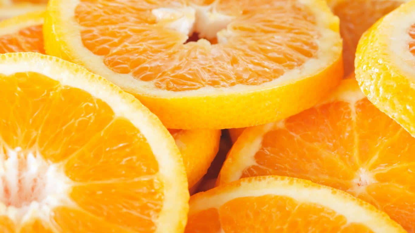 Orange Fruit 桌布 壁紙 — 多汁的柳橙片緊密堆疊，在明亮光線下展現出鮮豔的果肉和紋理分明的果皮。