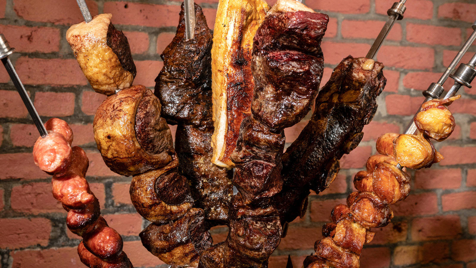 meat 桌布 壁紙 — 多汁的烤肉串在質樸的磚牆前滋滋作響，令人垂涎的特寫。