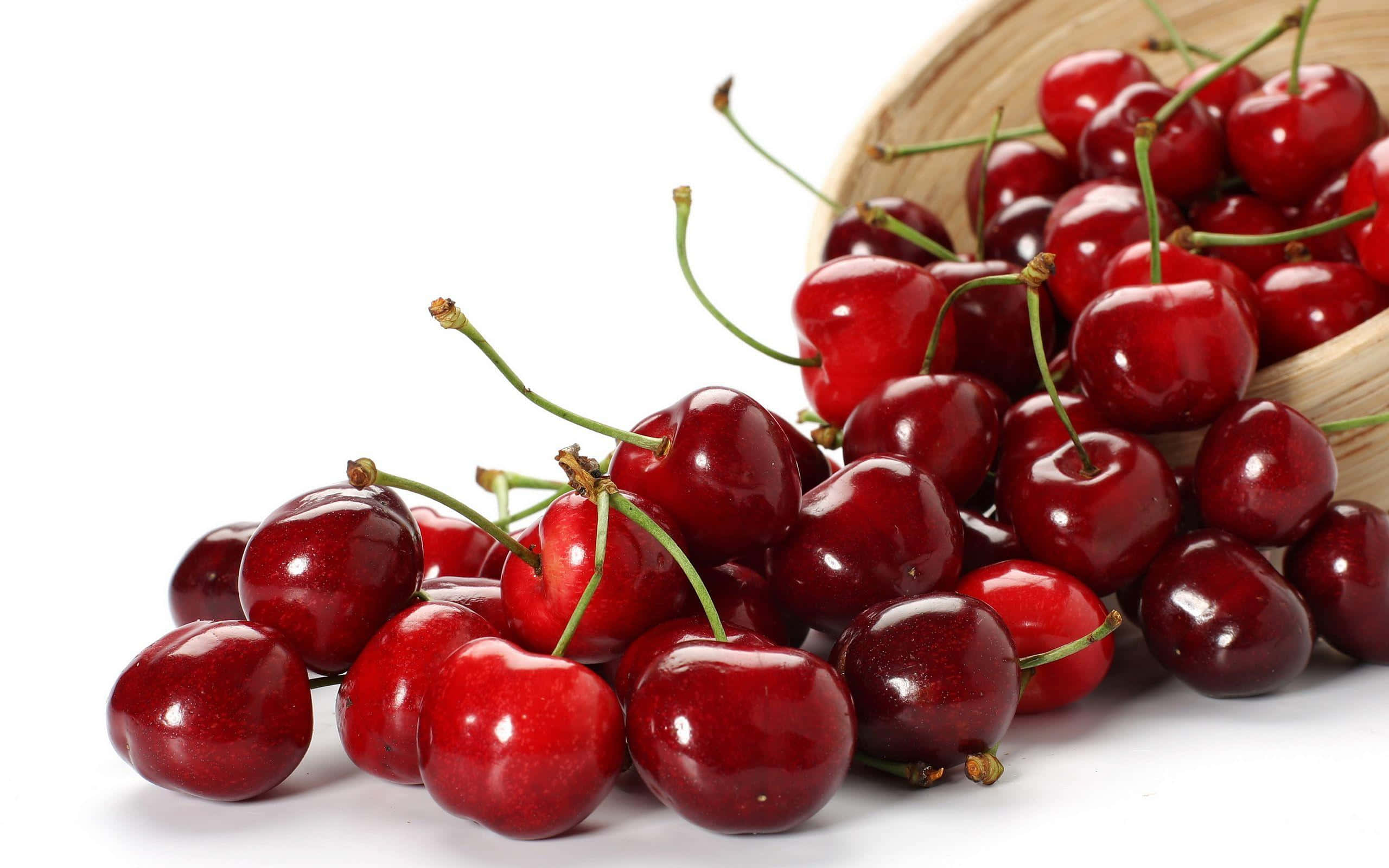 Cherry 桌布 壁紙 — 多汁的紅櫻桃從編織籃子中溢出，映襯在純白背景上，閃爍著自然露珠。