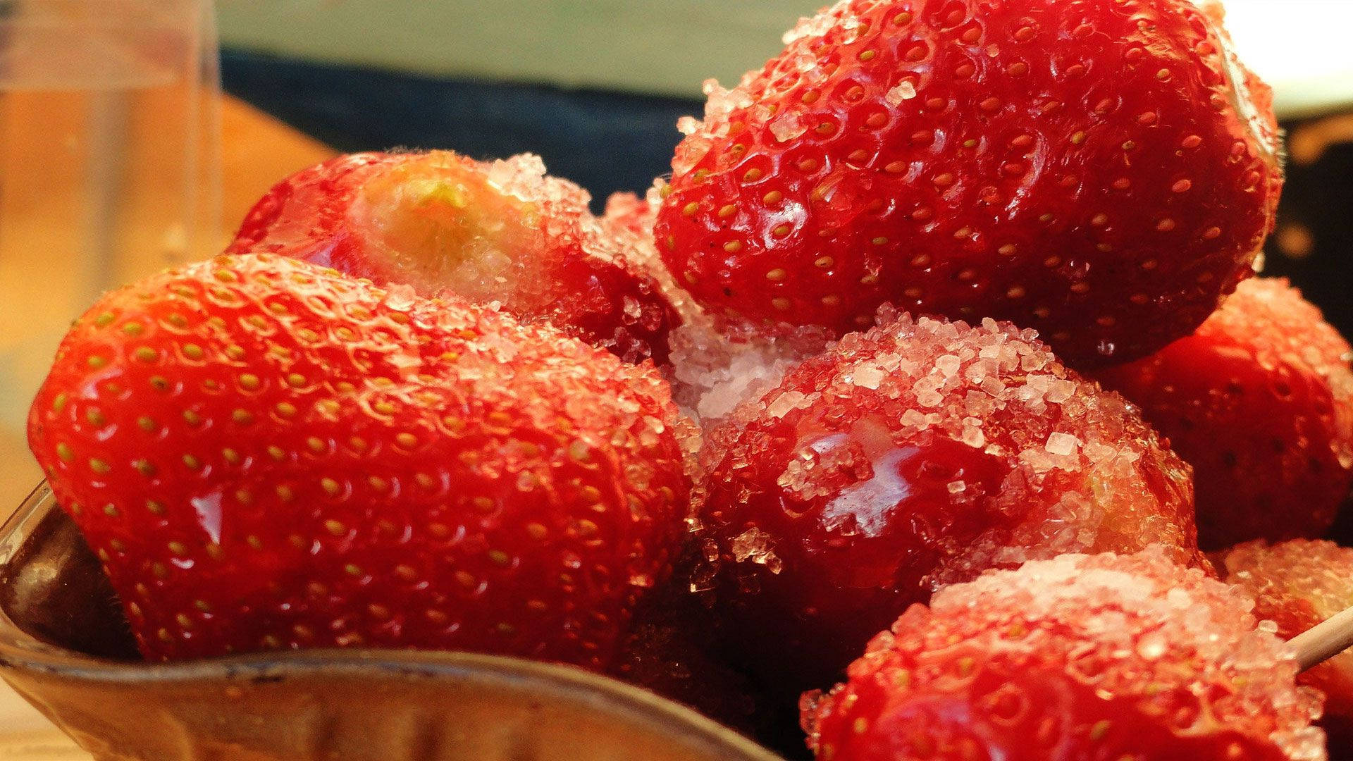 Berry 桌布 壁紙 — 多汁的紅色草莓在鄉村風格的碗中閃爍著粗糖晶體的光澤。