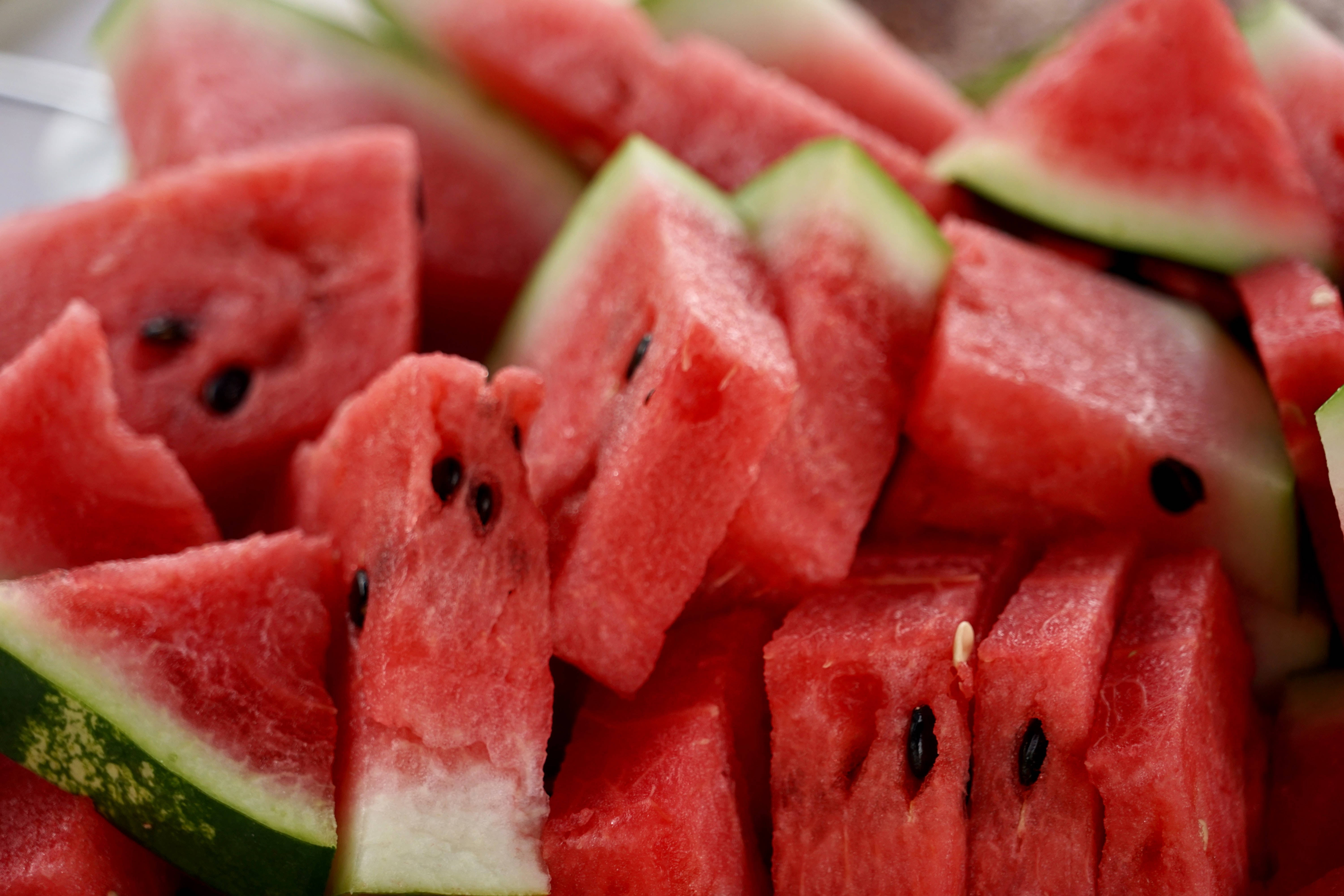 Watermelon 桌布 壁紙 — 多汁的紅色西瓜切片，帶有黑色種子和綠色外皮，堆疊在一起的特寫鏡頭。