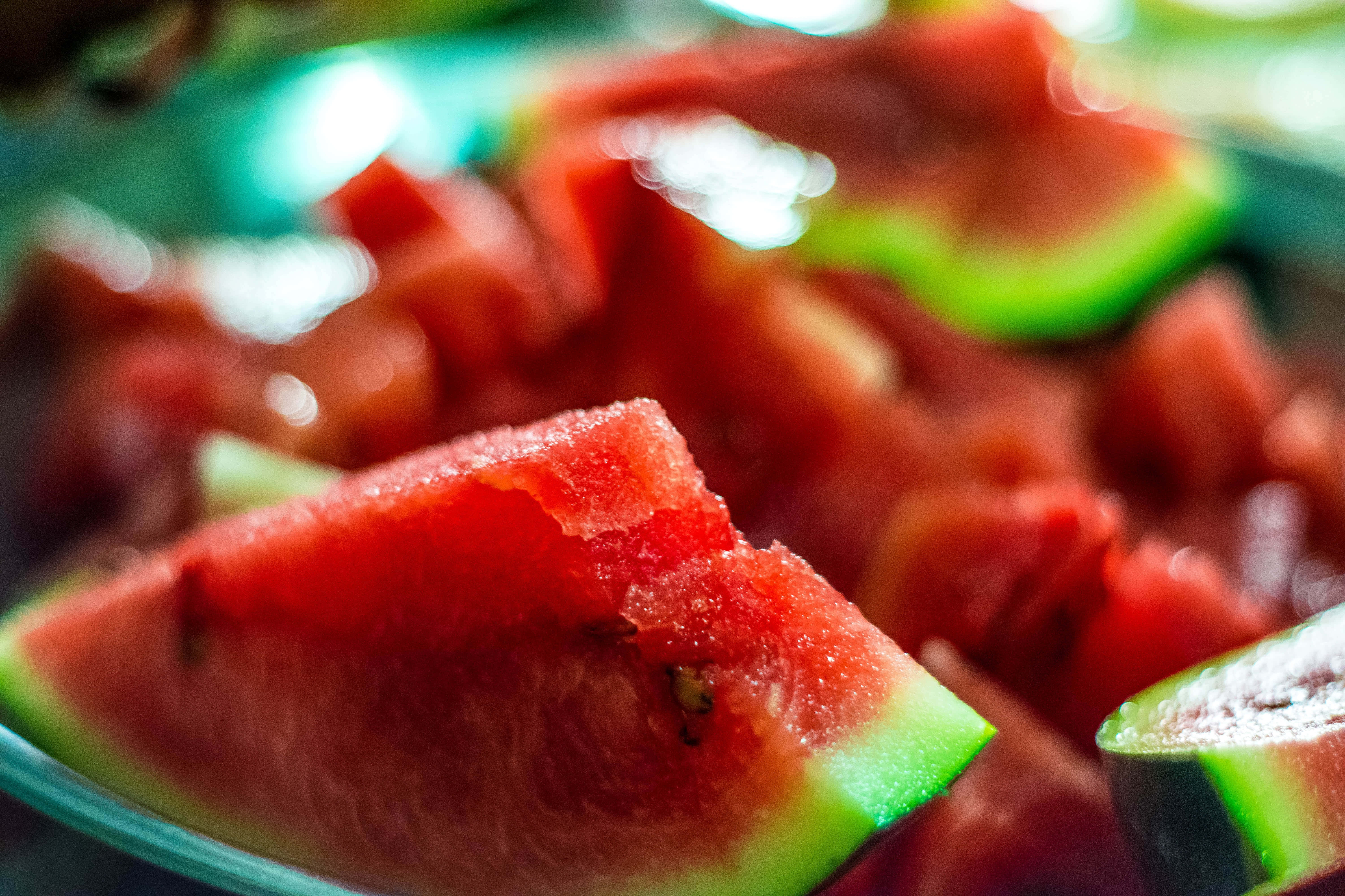 Summer Fruits 桌布 壁紙 — 多汁的紅色西瓜片，帶有綠色外皮，在柔和光線下於淺碗中閃閃發光。