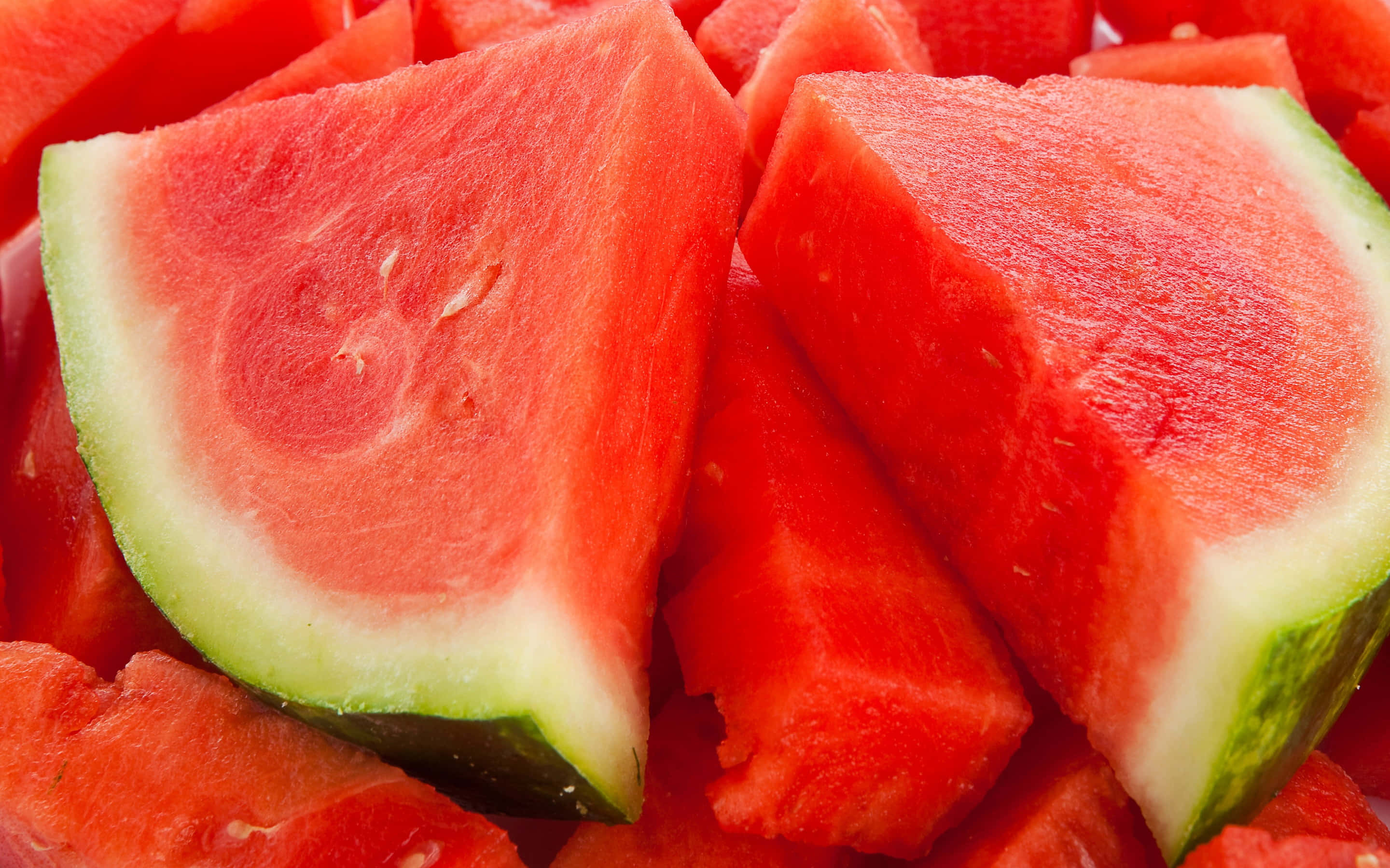 Fruit 桌布 壁紙 — 多汁的紅色西瓜片，帶綠色外皮，堆疊在一起，展現出鮮豔的果肉和種子。