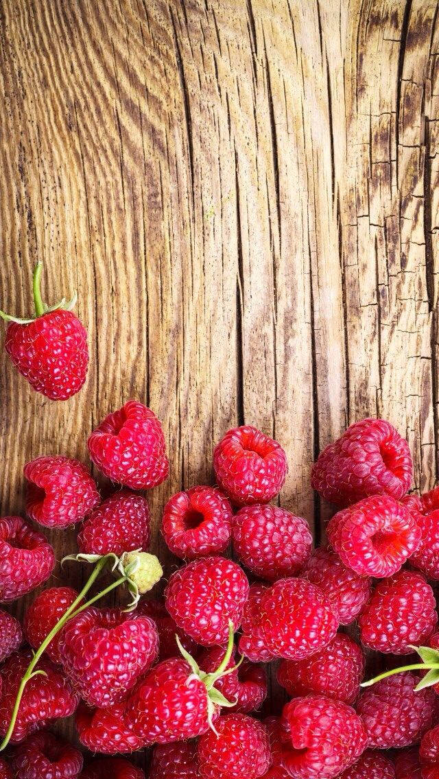 Fruit 桌布 壁紙 — 多汁的紅覆盆子散落在經過風化的木質表面上，帶有豐富的木紋紋理。