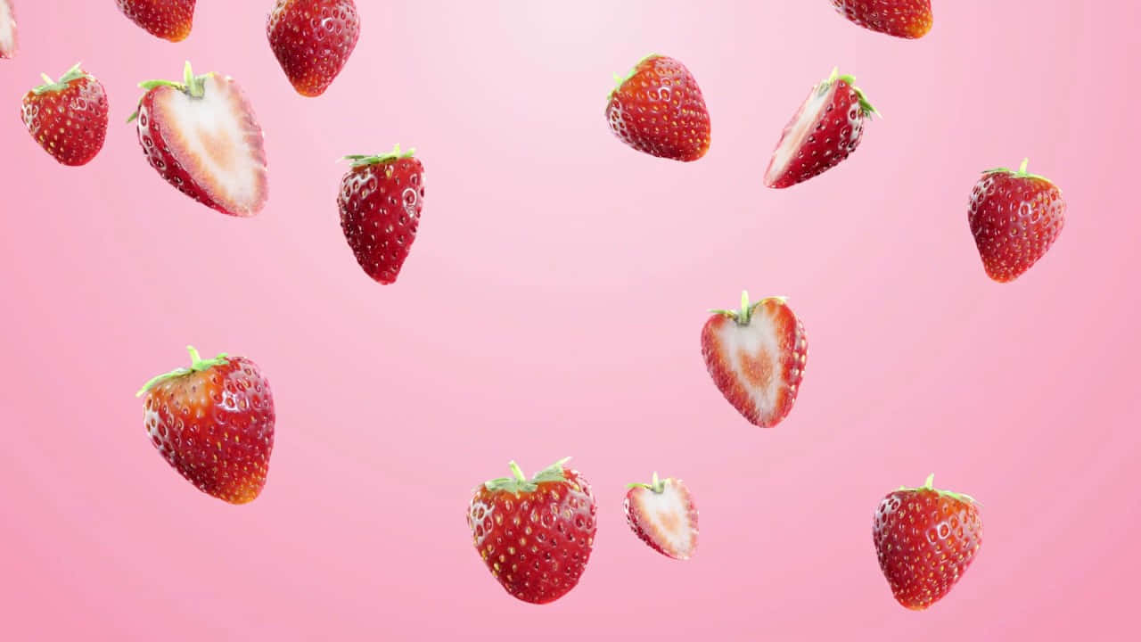 Strawberries 桌布 壁紙 — 多汁的草莓完整和半切，優雅地漂浮在柔和的粉紅色漸變背景上。