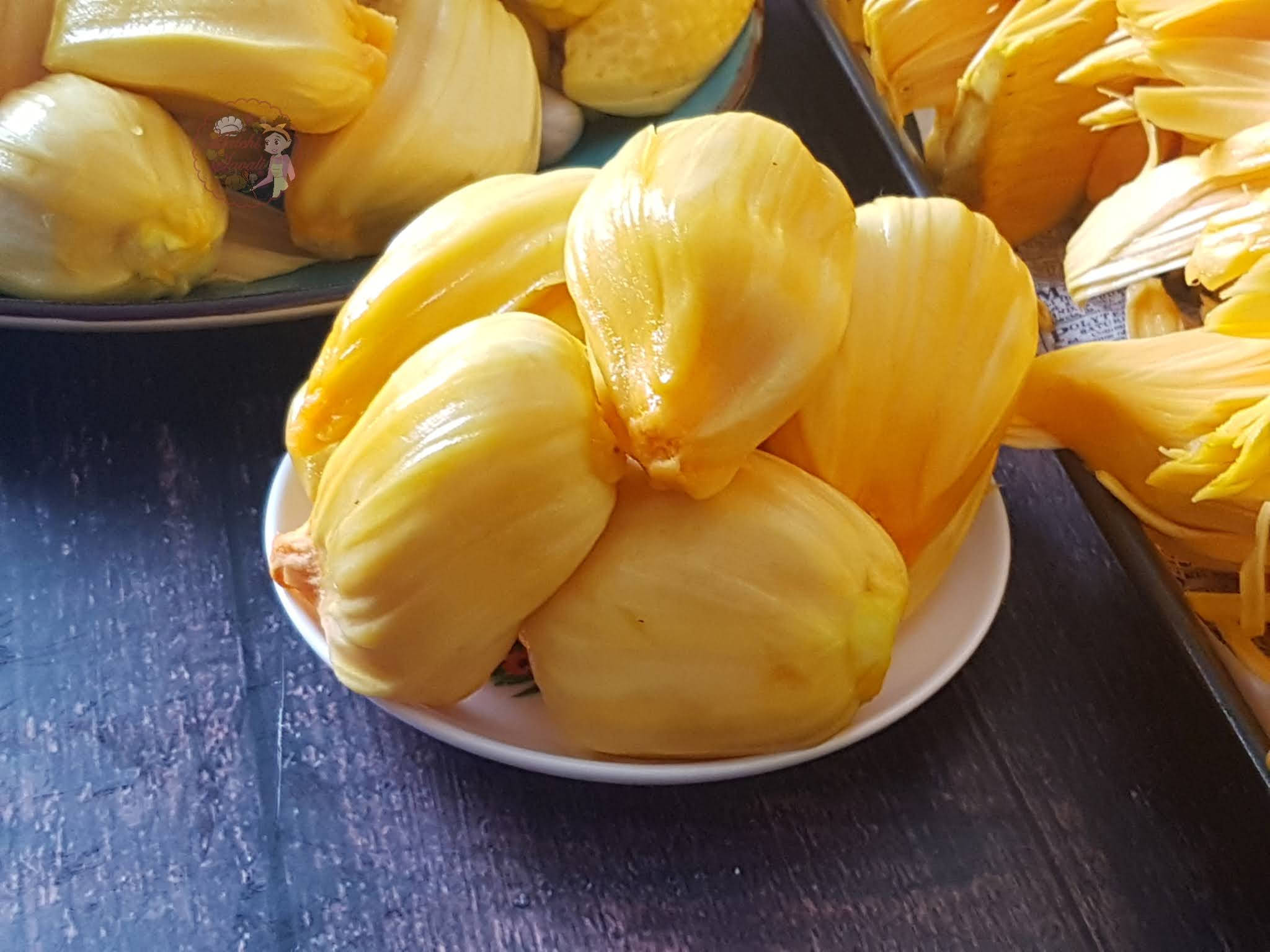 Jackfruit 桌布 壁紙 — 多汁的金色波羅蜜塊在白色盤子上閃閃發光，襯托著深色木質表面。