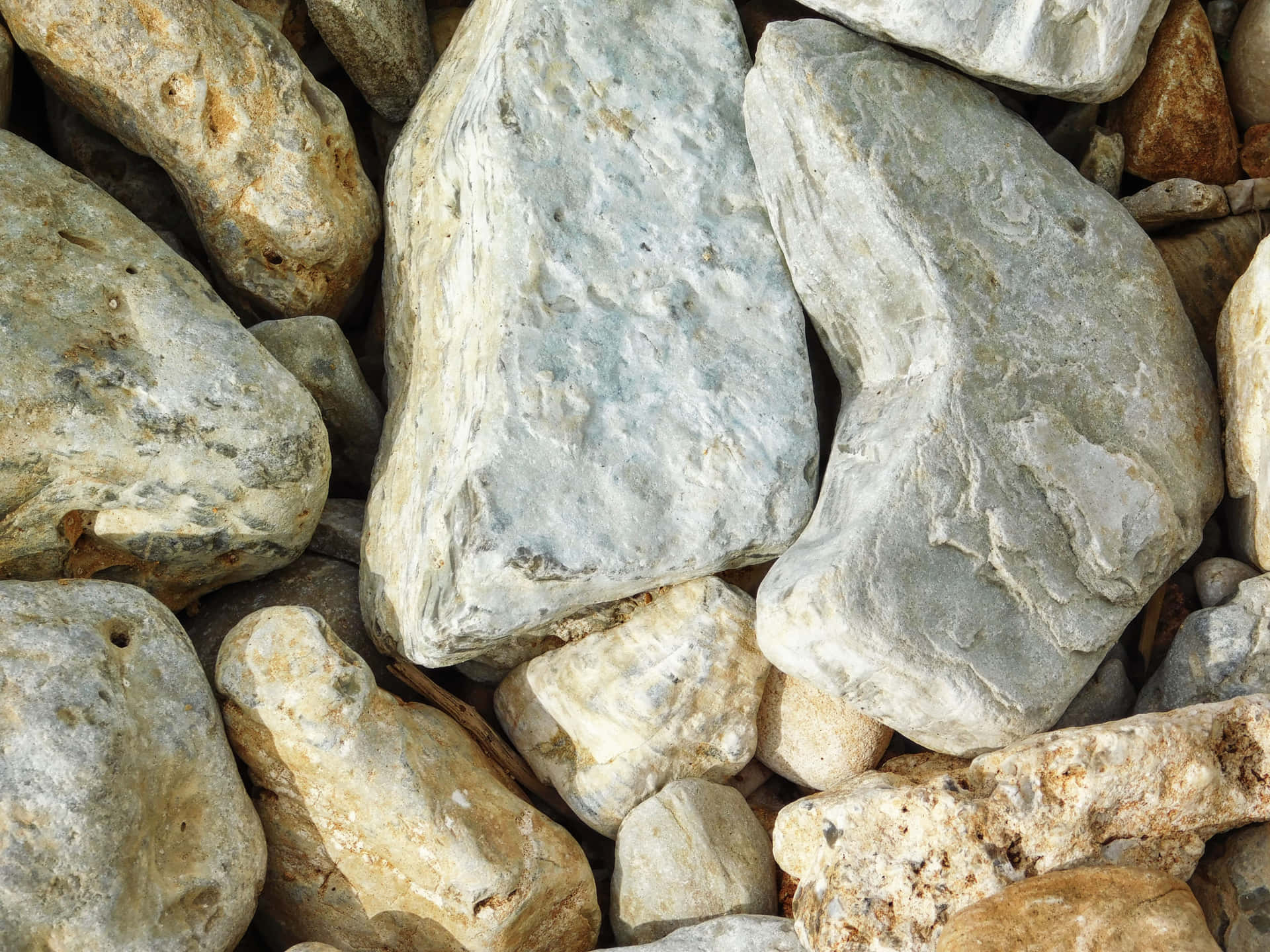 Stone texture 壁紙 — 多種紋理石頭的特寫，呈現自然大地色調，帶有柔和陰影和高光。