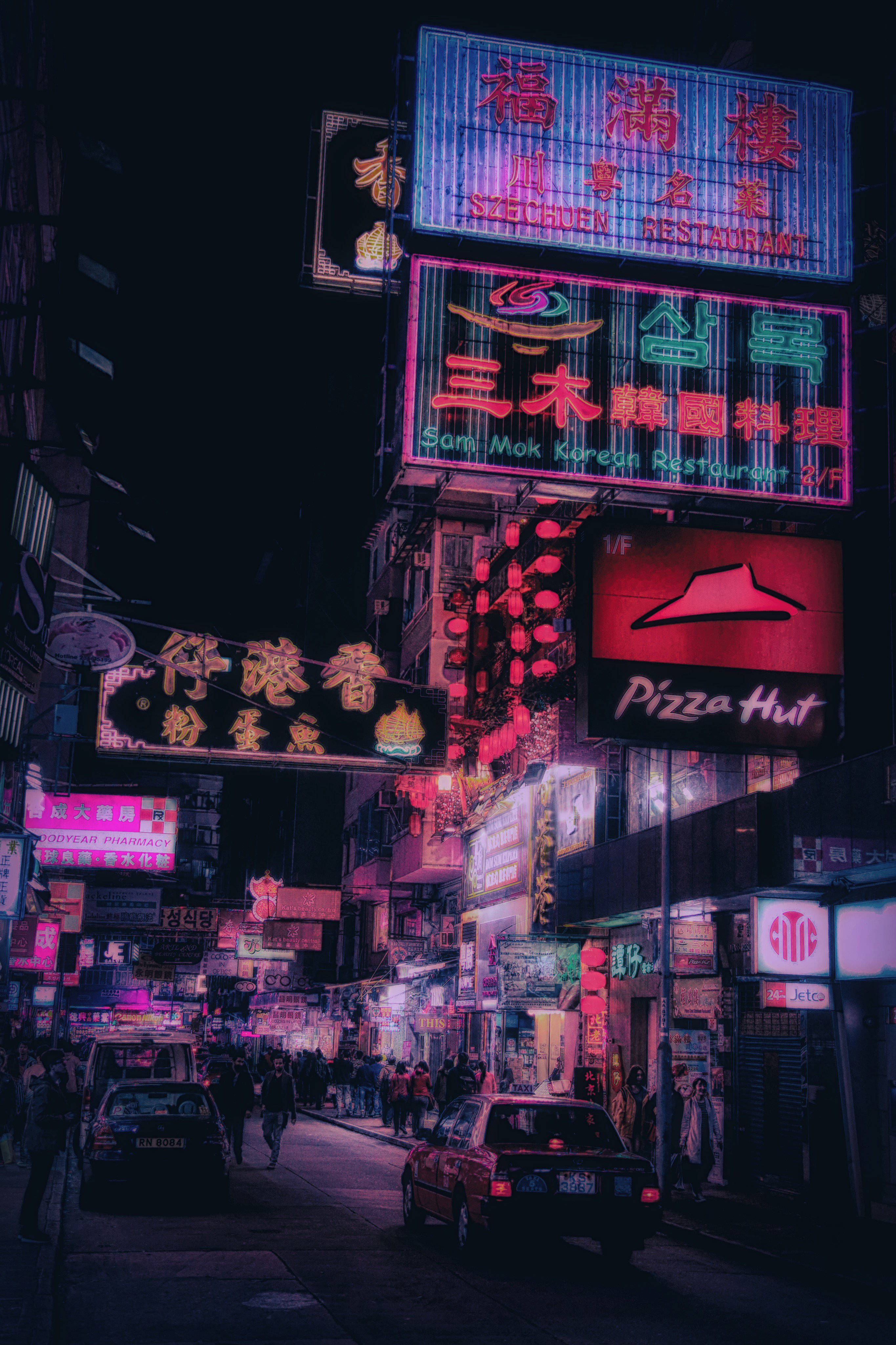 Asia 桌布 壁紙 — 多種語言的鮮豔霓虹招牌照亮了繁忙的夜間街道，行人與車輛穿梭其中。