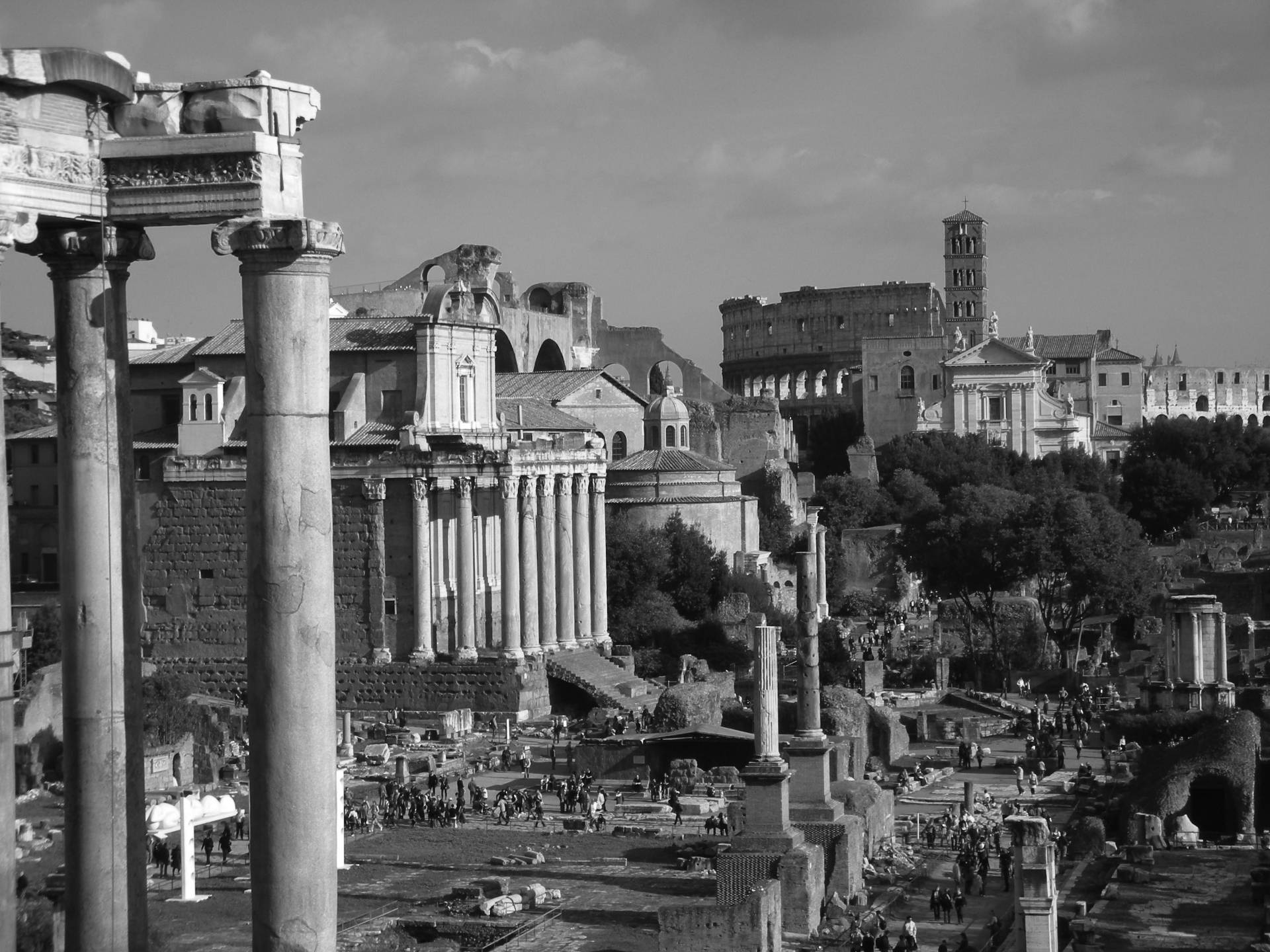 Rome 桌布 壁紙 — 多雲天空下，古羅馬遺址的單色景觀，有高聳的柱子和歷史建築。