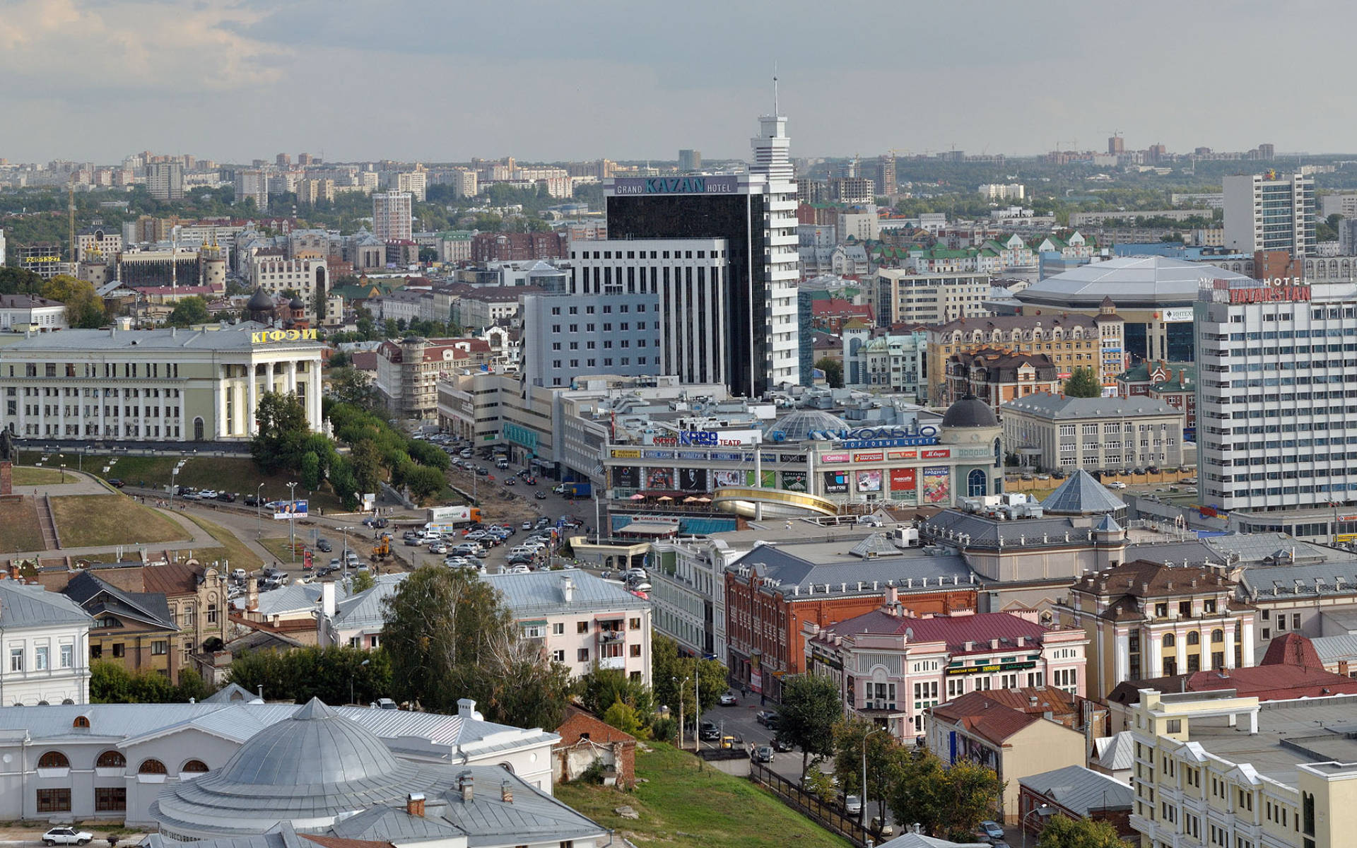 Kazan 桌布 壁紙 — 多雲天空下，現代摩天大樓與歷史建築交錯的廣闊城市景觀鳥瞰圖。