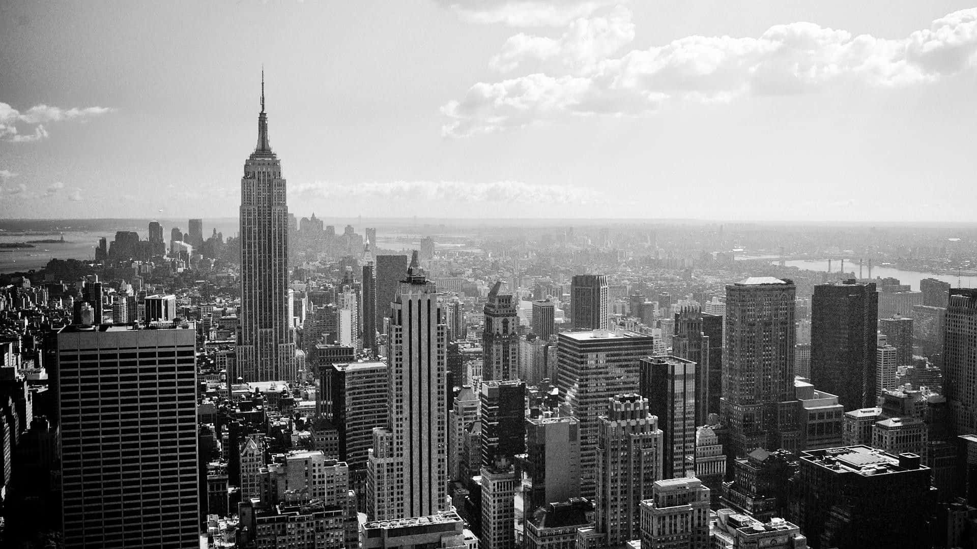 New York 桌布 壁紙 — 多雲天空下，由帝國大廈主導的紐約市天際線的單色航拍圖。