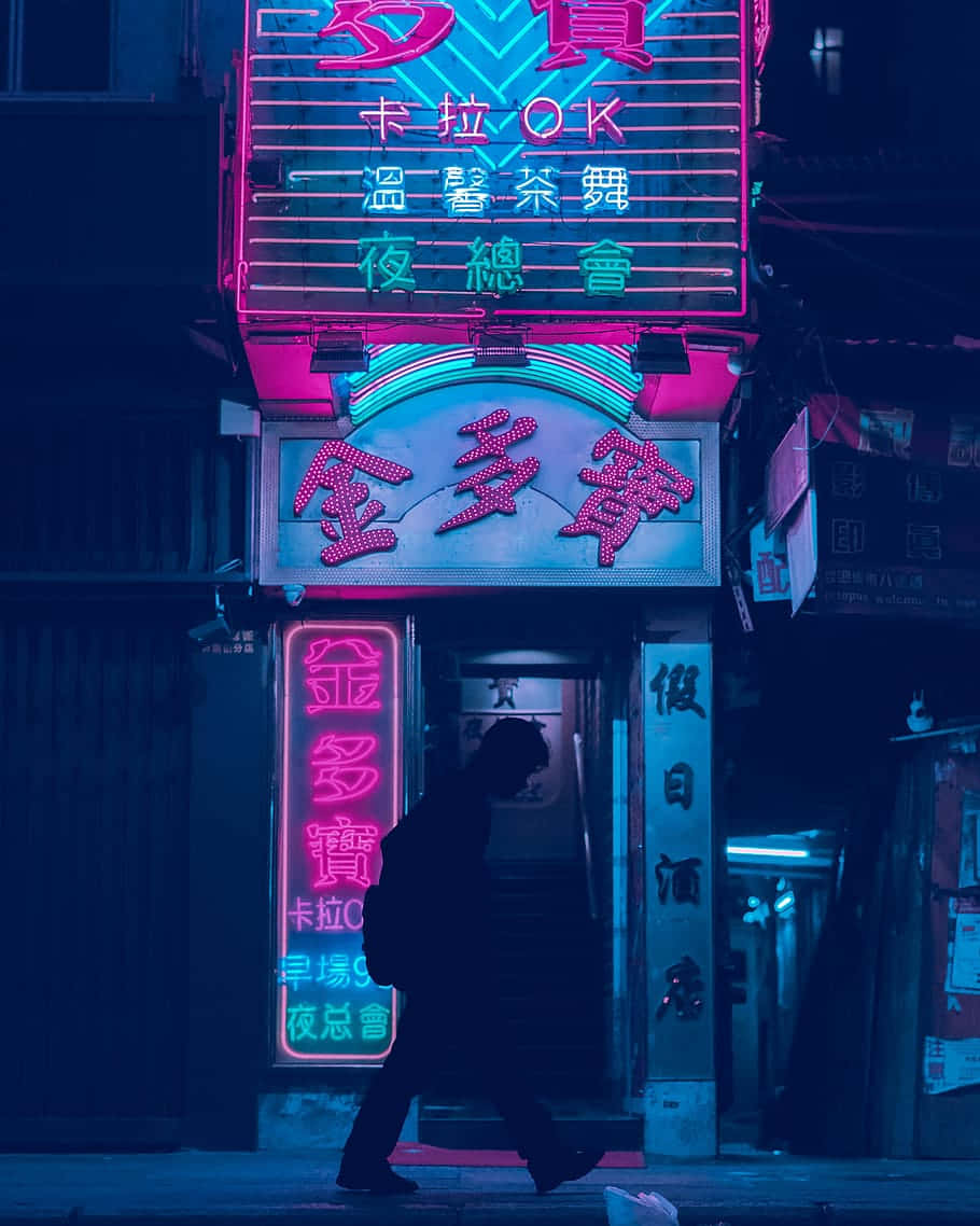 美學 桌布 壁紙 — 夜晚，一個孤獨的身影走過昏暗城市小巷中發光的粉紅色和藍色霓虹燈標誌。