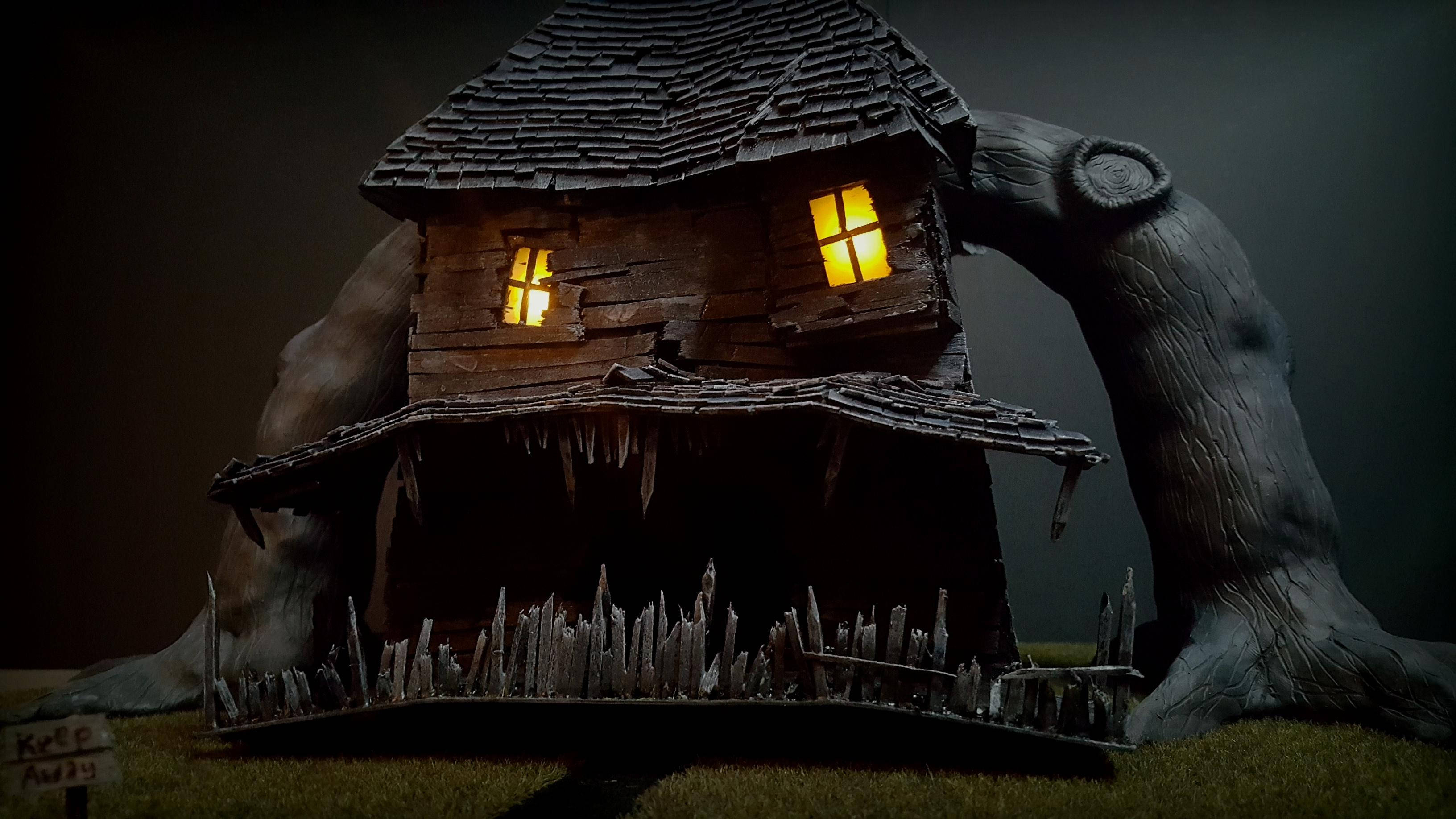 Monster House 桌布 壁紙 — 夜晚，一座詭異的木屋，窗戶發著光，隱藏在一棵巨大的多節樹下。