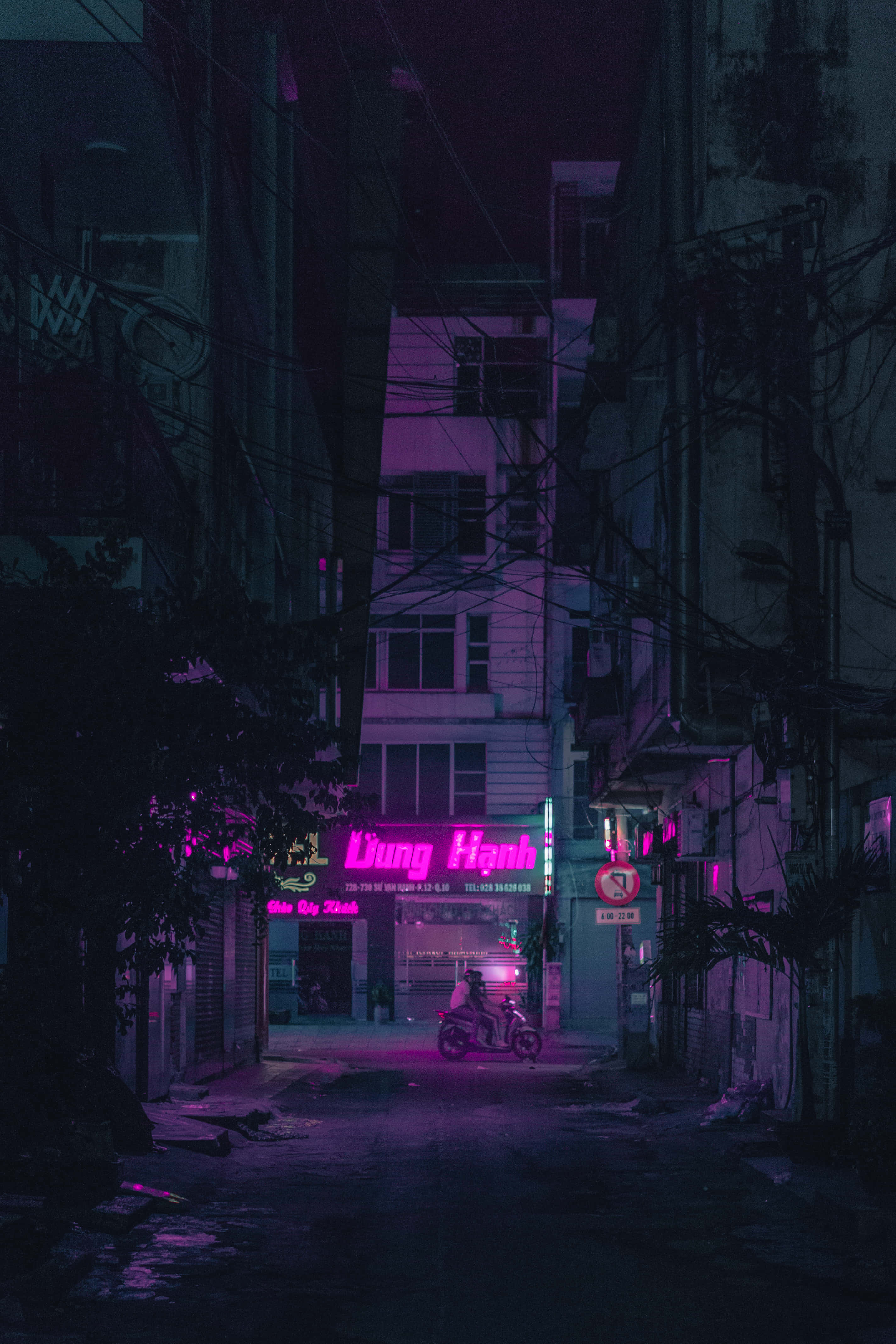 桌布 壁紙 — 夜晚，一架孤獨的機車在狹窄陰暗的城市小巷中，在霓虹粉紅招牌下發光。