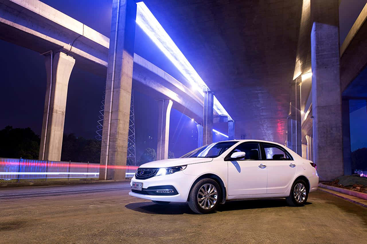 Geely 桌布 壁紙 — 夜晚，一輛白色轎車停放在發出藍色光芒的高架橋下，光跡掠過。