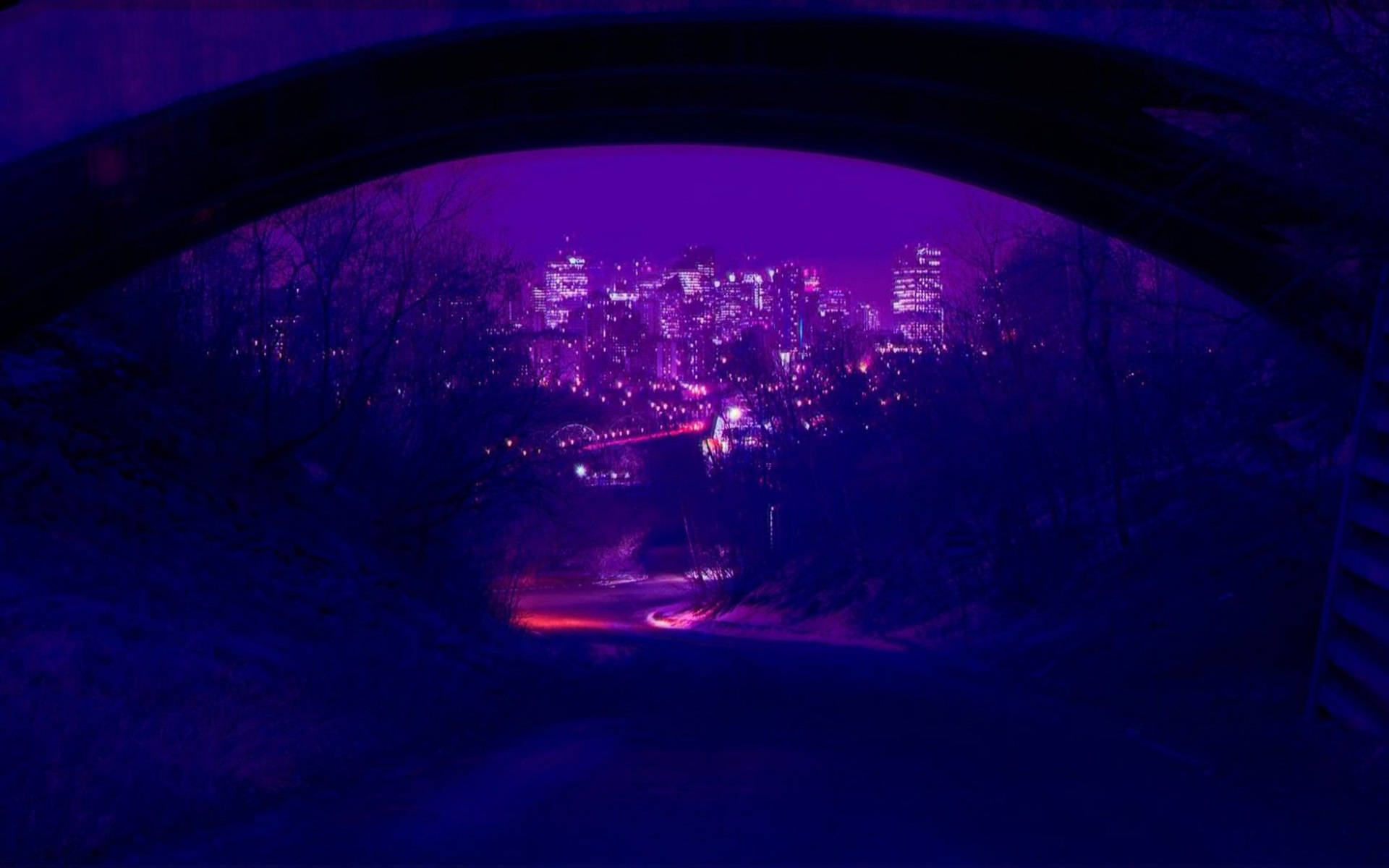 Dark Purple Collage Aesthetic 桌布 壁紙 — 夜晚，城市天際線透過黑暗的石拱門散發出紫色和藍色的光芒，以光禿的樹木和蜿蜒的道路為框架。