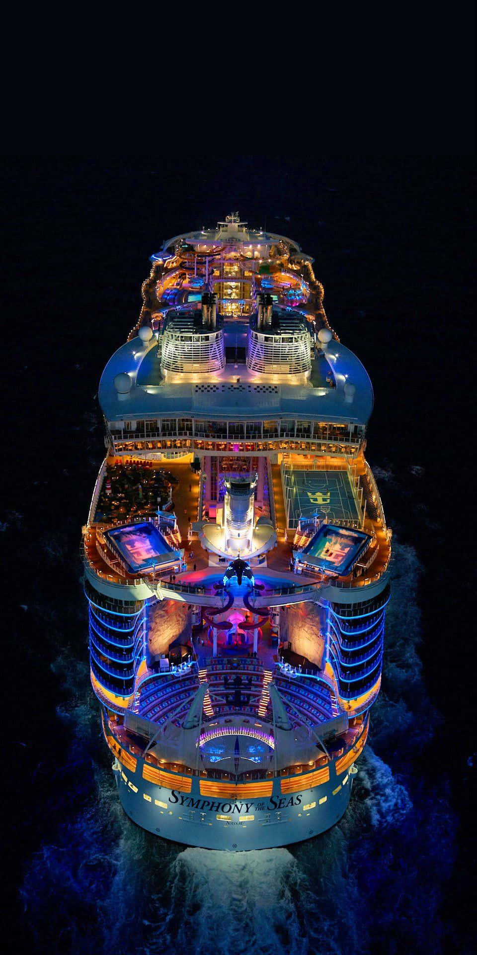 Cruise 桌布 壁紙 — 夜晚，海洋交響號郵輪在黑暗的海洋上閃爍著鮮豔燈光的鳥瞰圖。