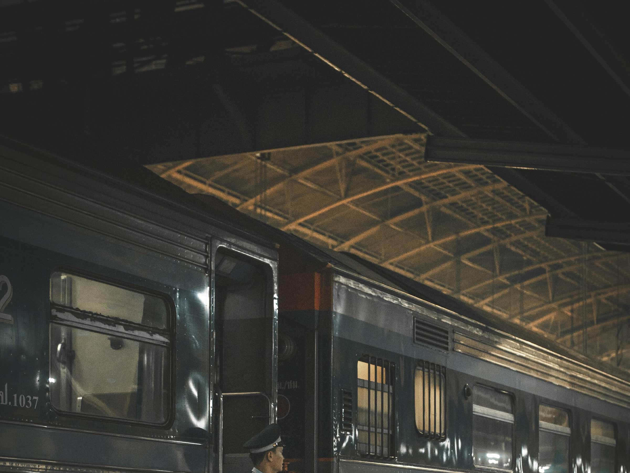 火車 桌布 壁紙 — 夜晚，金屬屋頂下的火車車廂，車長站在門邊。