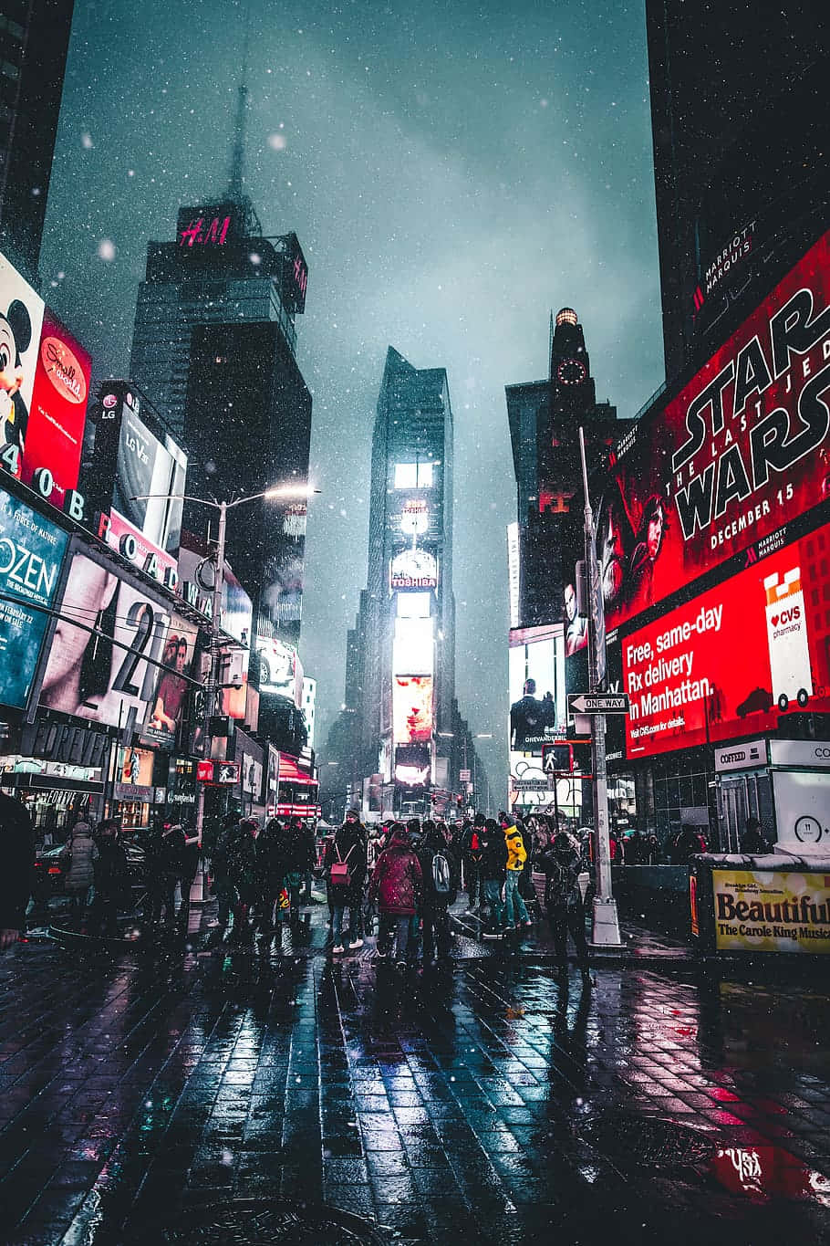 攝影 桌布 壁紙 — 夜晚，霓虹燈照亮的時代廣場下著雪，潮濕的人行道反射出鮮豔的廣告牌和人群。