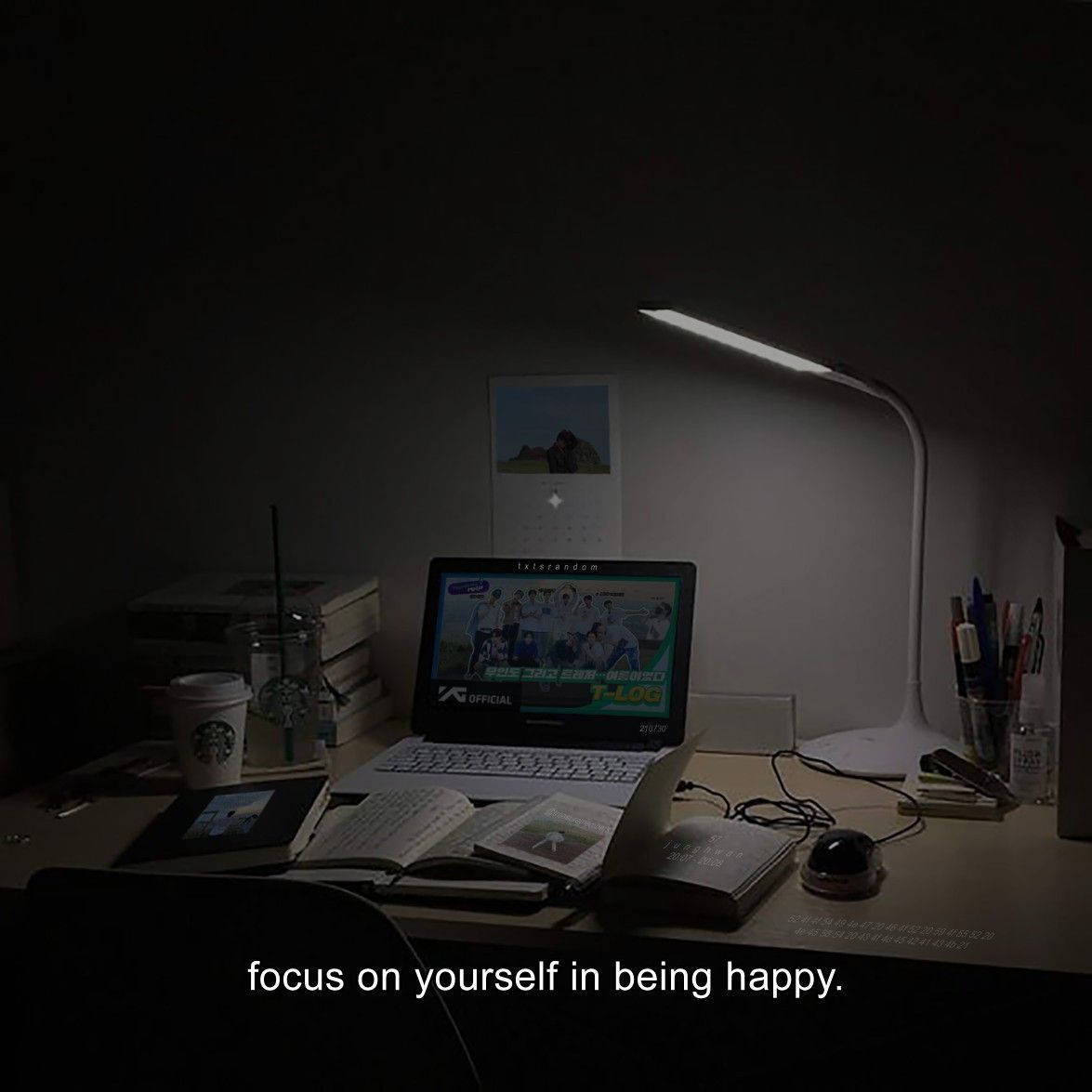 夜晚一張凌亂的書桌，由一盞燈照亮，上面有筆記型電腦、書籍和咖啡杯。 — 深色引言 壁紙