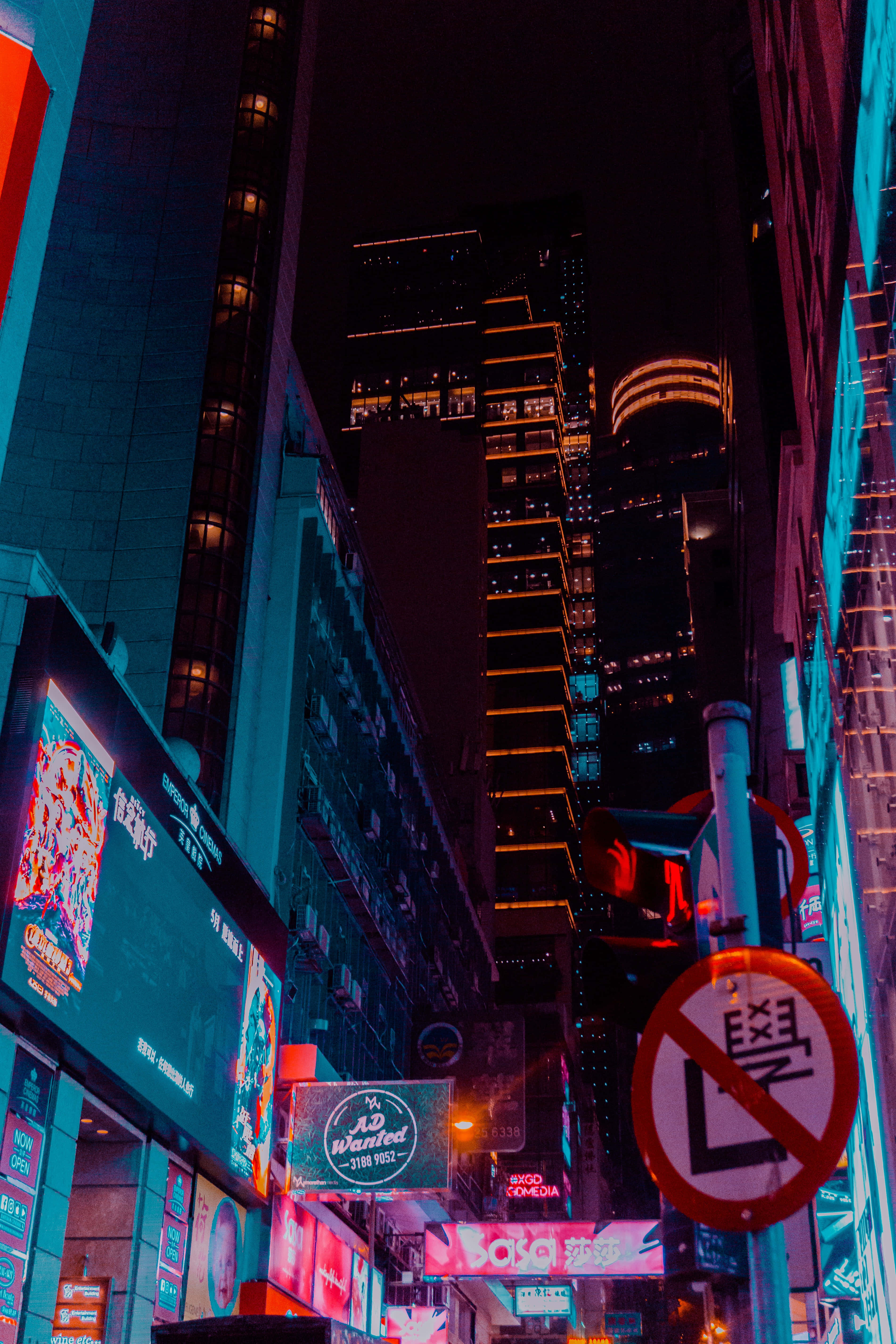 Blue Neon Lights 桌布 壁紙 — 夜晚一條充滿活力的霓虹燈城市街道，高聳的摩天大樓閃爍著電光藍和紅色調。