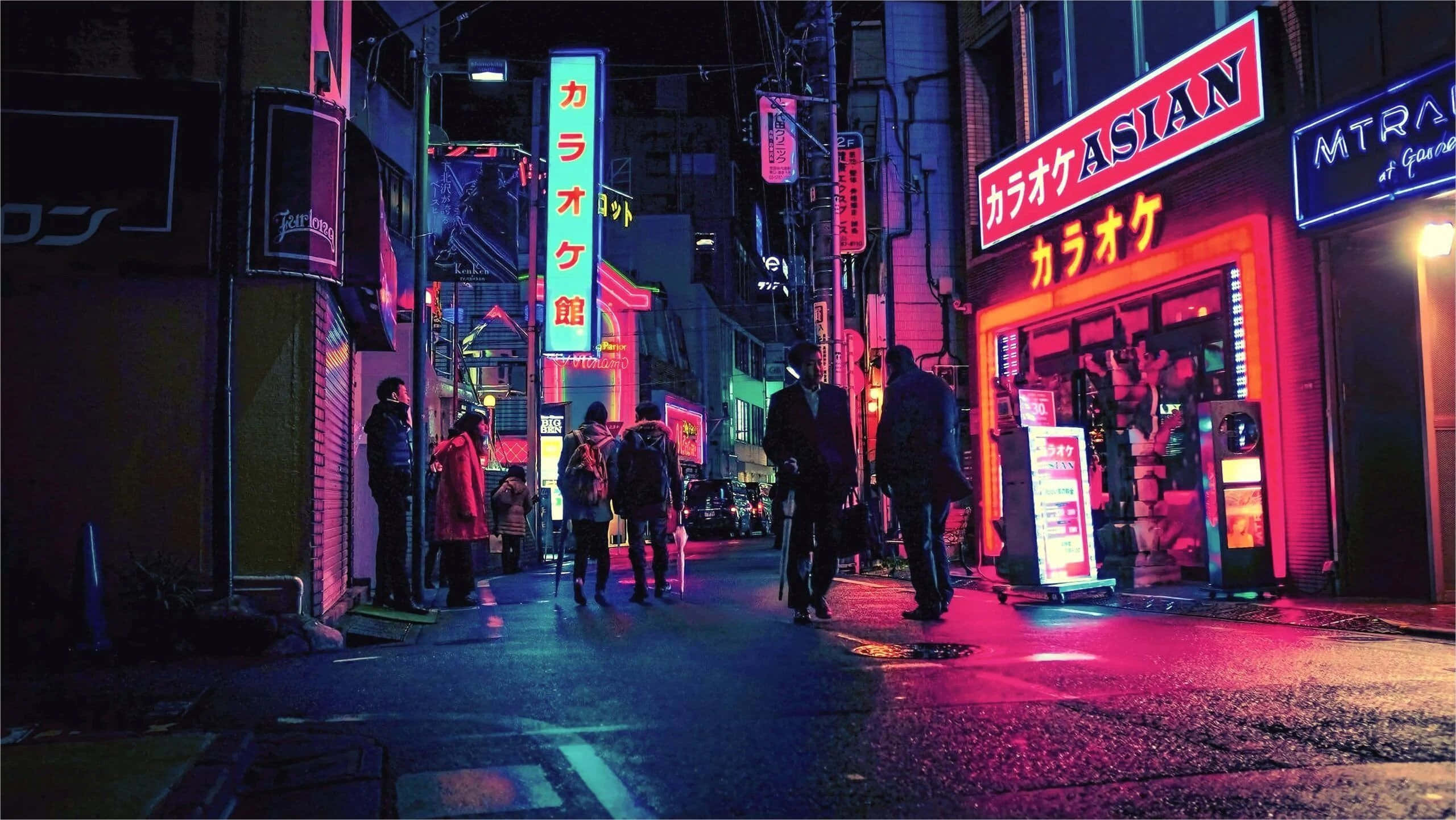 Street Light 桌布 壁紙 — 夜晚一條充滿霓虹燈的東京小巷，行人走過發光的卡拉OK和餐廳招牌，倒影在濕漉漉的人行道上。