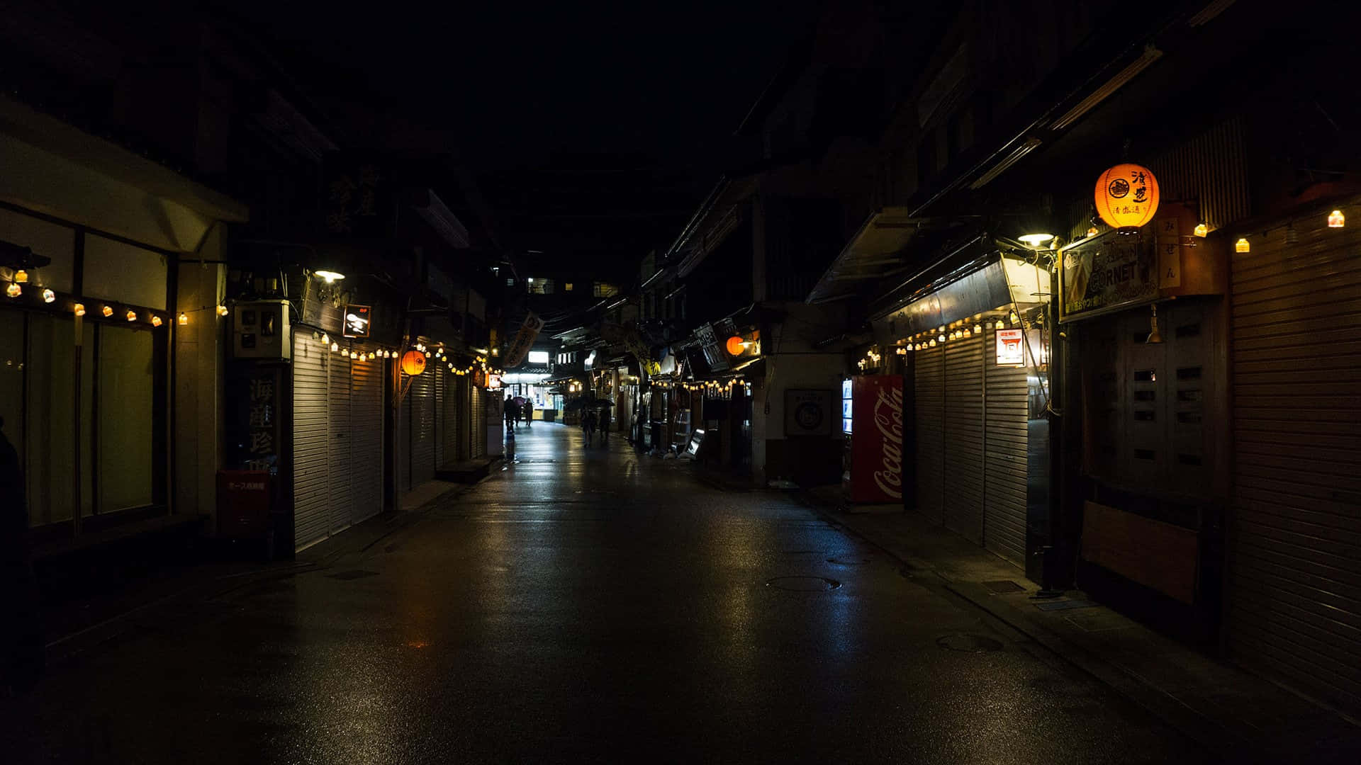 Night Street 桌布 壁紙 — 夜晚一條狹窄潮濕的小巷，被燈串和發光的燈籠照亮，倒映在路面上。
