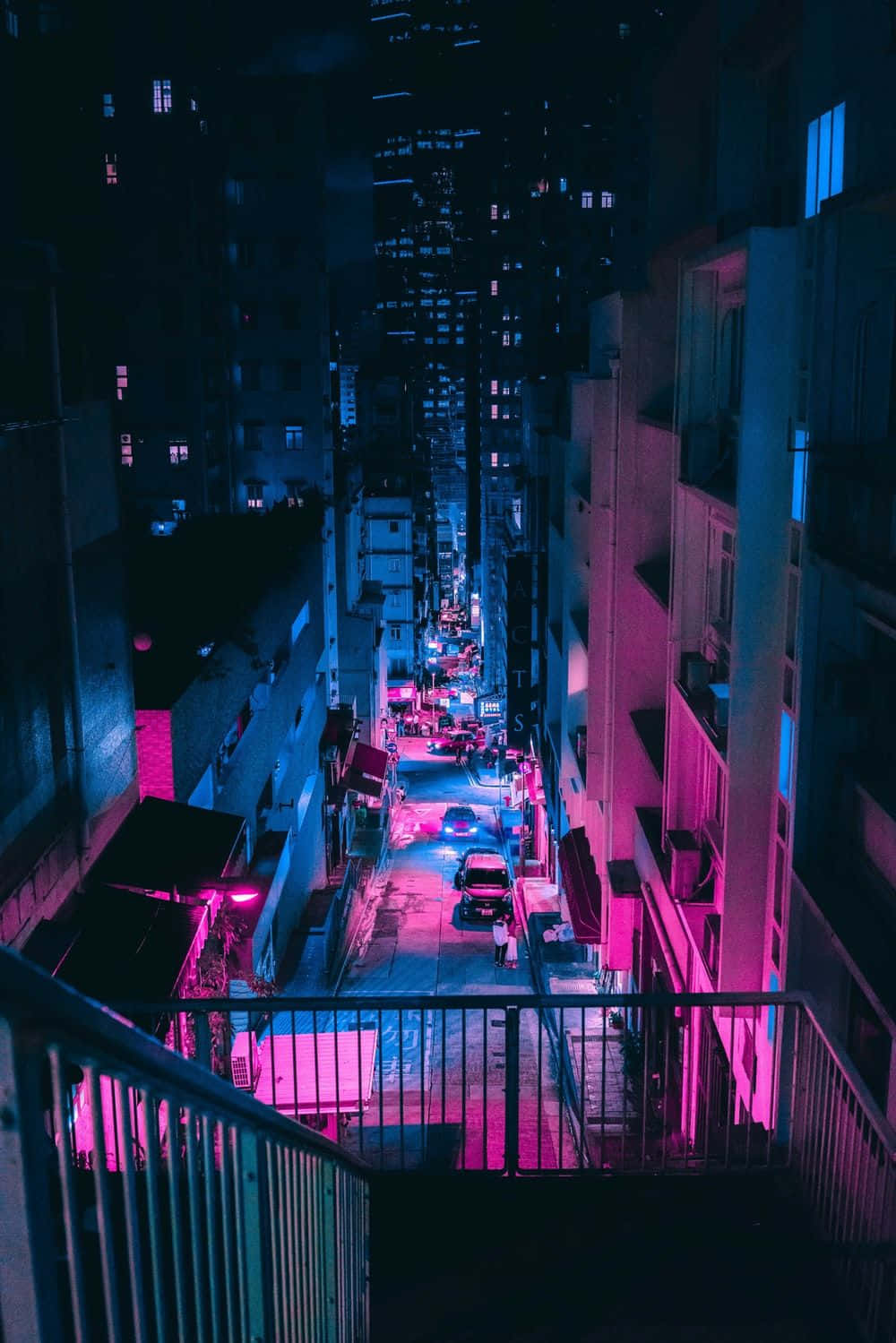 霓虹藍動畫 桌布 壁紙 — 夜晚一條狹窄的城市小巷，沐浴在鮮豔的粉紅和藍色霓虹燈光中，燈光反射在濕漉漉的路面上。