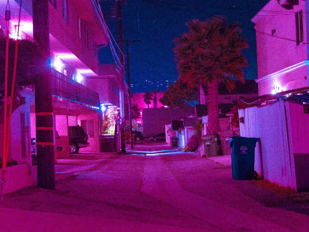 Neon Aesthetic Phone 桌布 壁紙 — 夜晚一條狹窄的城市小巷，被鮮豔的粉紅色和藍色霓虹燈照亮，兩旁種有棕櫚樹和建築物。