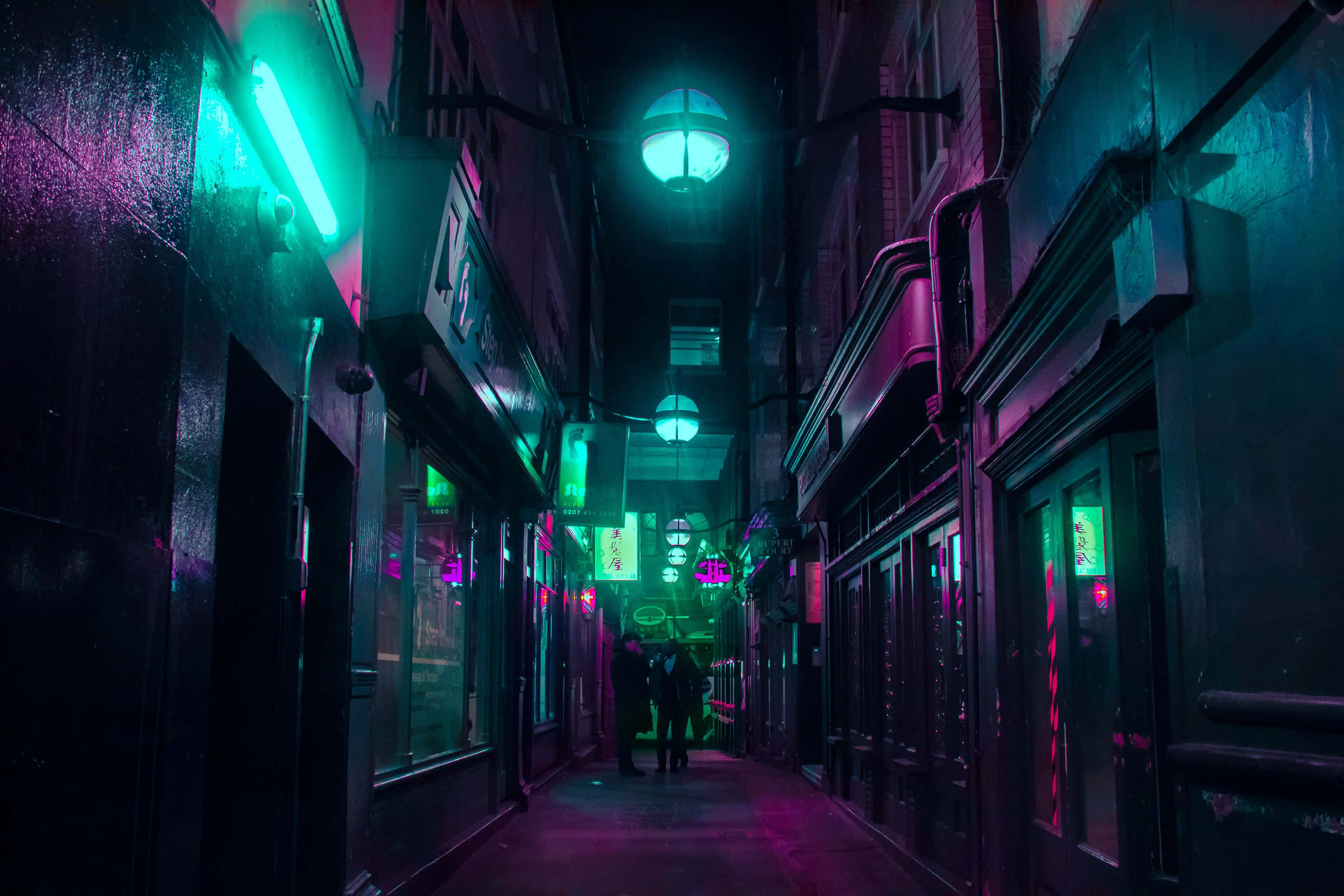 Alleyway 桌布 壁紙 — 夜晚一條狹窄的雨巷，被商店櫥窗的霓虹綠和粉紅燈光籠罩，有剪影人物走遠。